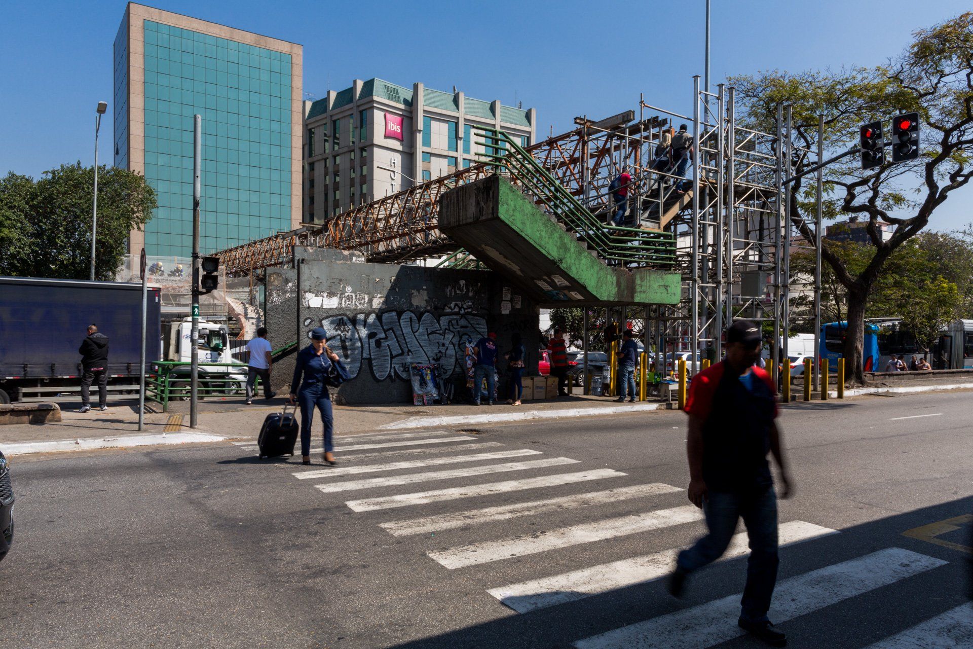 Um homem está atravessando a rua em frente a um grande edifício