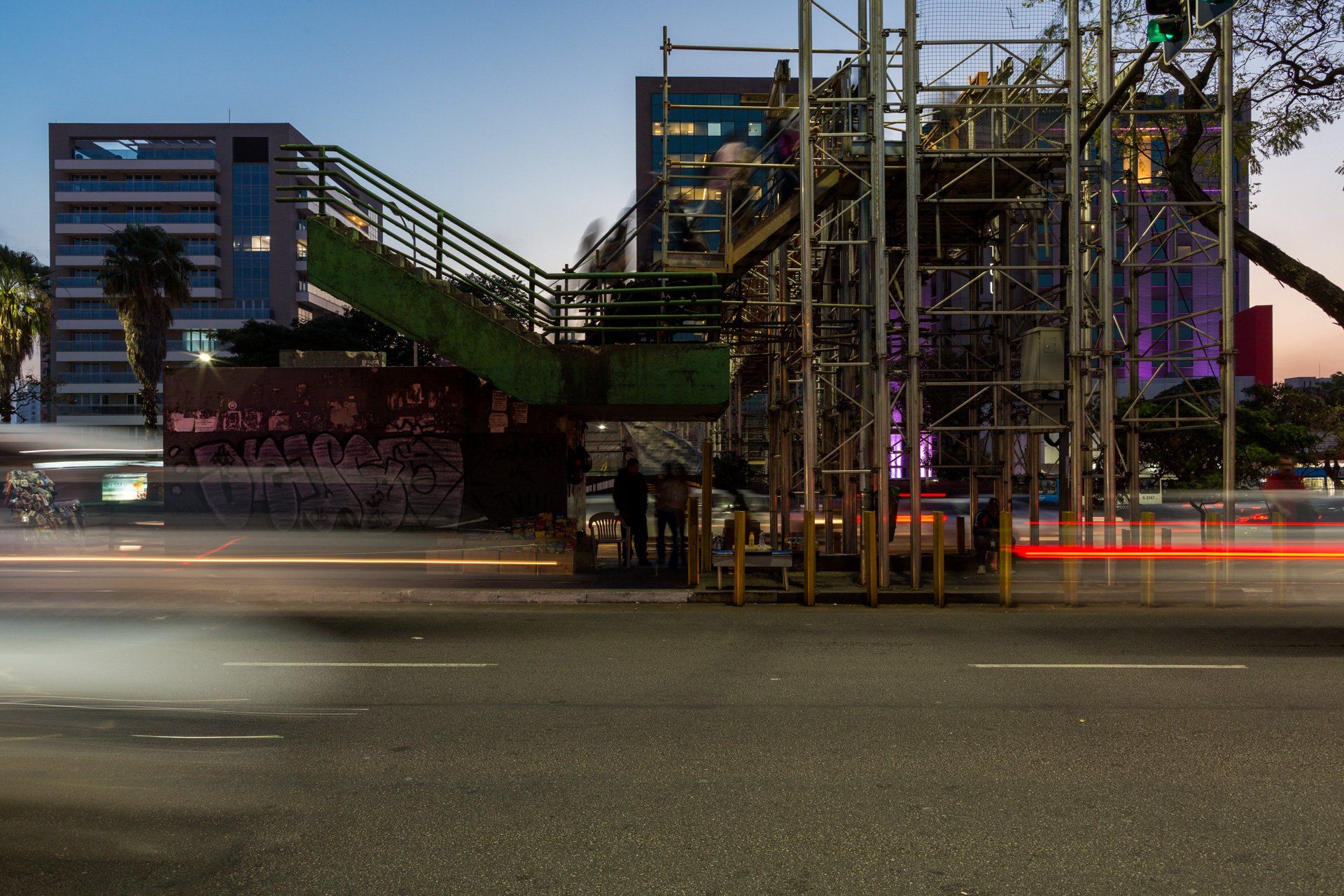 Uma imagem desfocada de uma rua com uma ponte ao fundo.