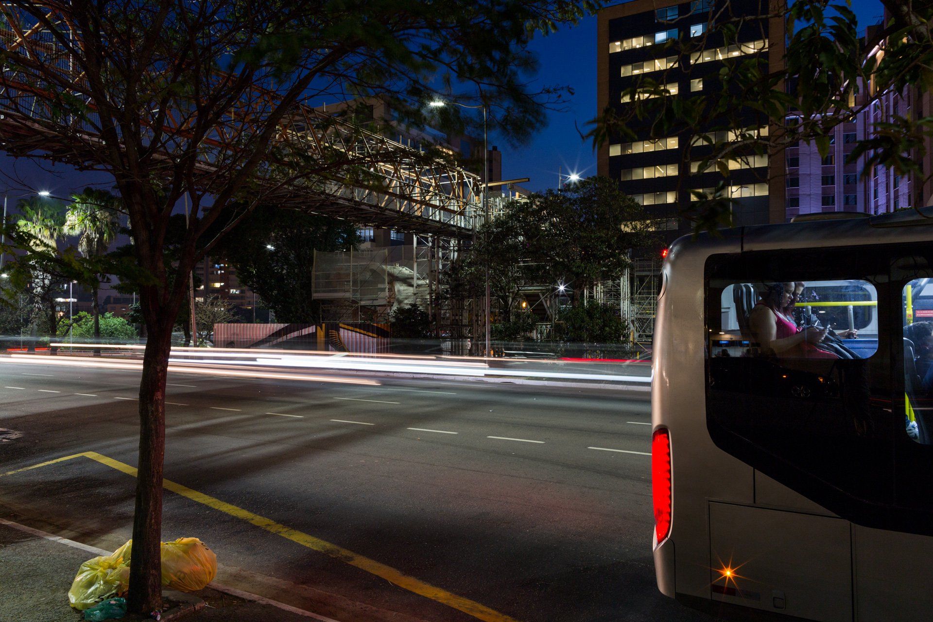 Um ônibus está passando por uma rua da cidade à noite.