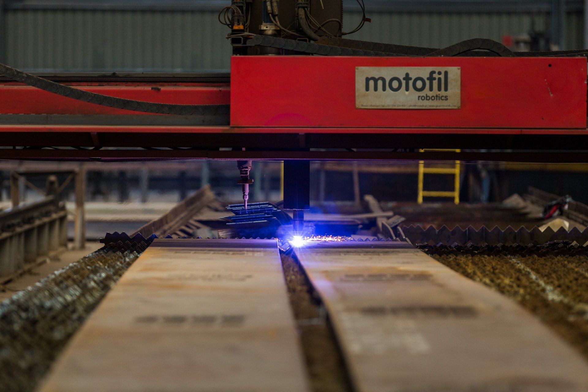 Uma máquina está cortando um pedaço de metal em uma fábrica.