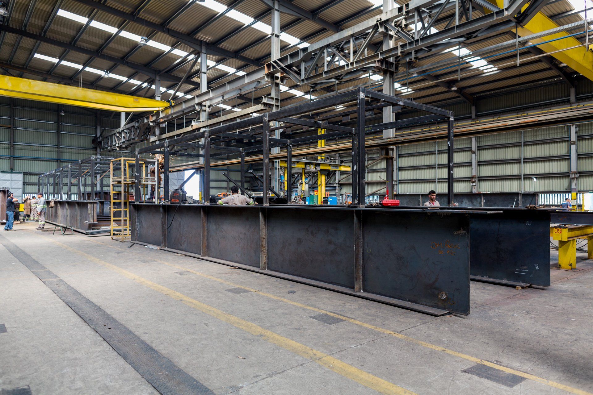 Uma grande estrutura metálica está sendo construída em uma fábrica