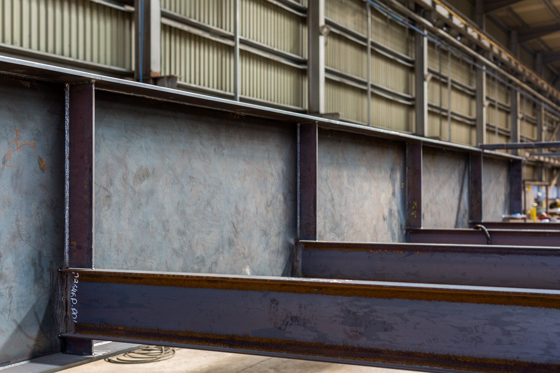 Uma grande viga de metal está em um armazém próximo a uma parede.