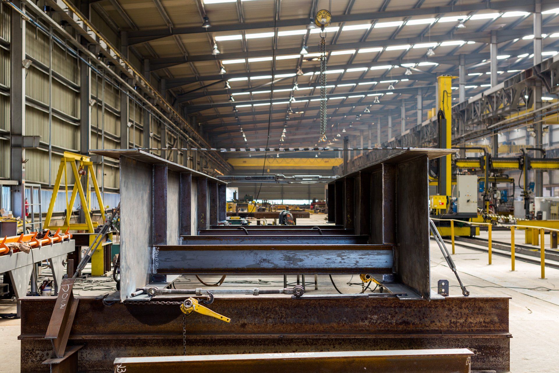 Uma grande estrutura metálica está sendo construída em uma fábrica.