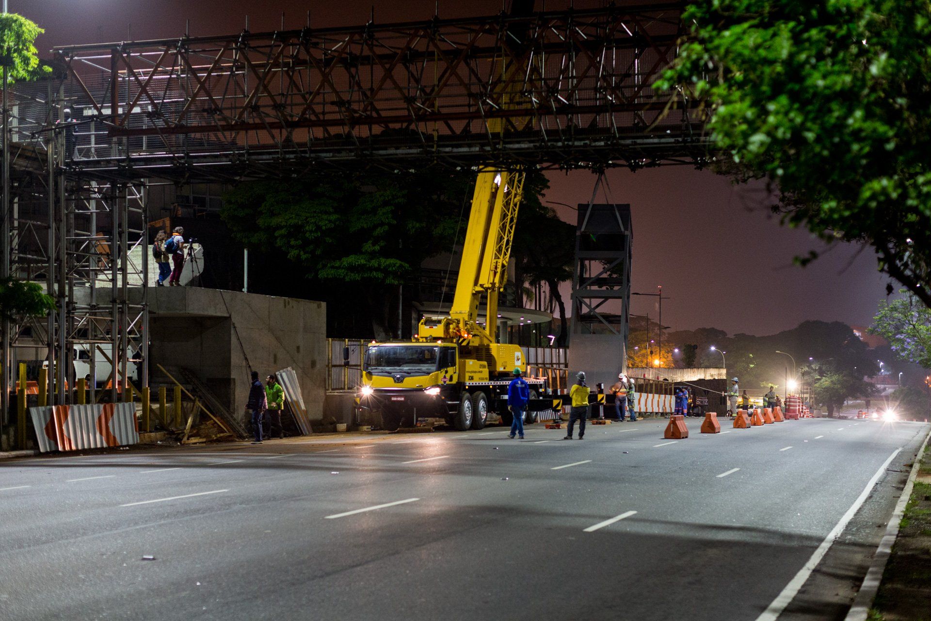 Um caminhão amarelo está estacionado na beira da estrada à noite