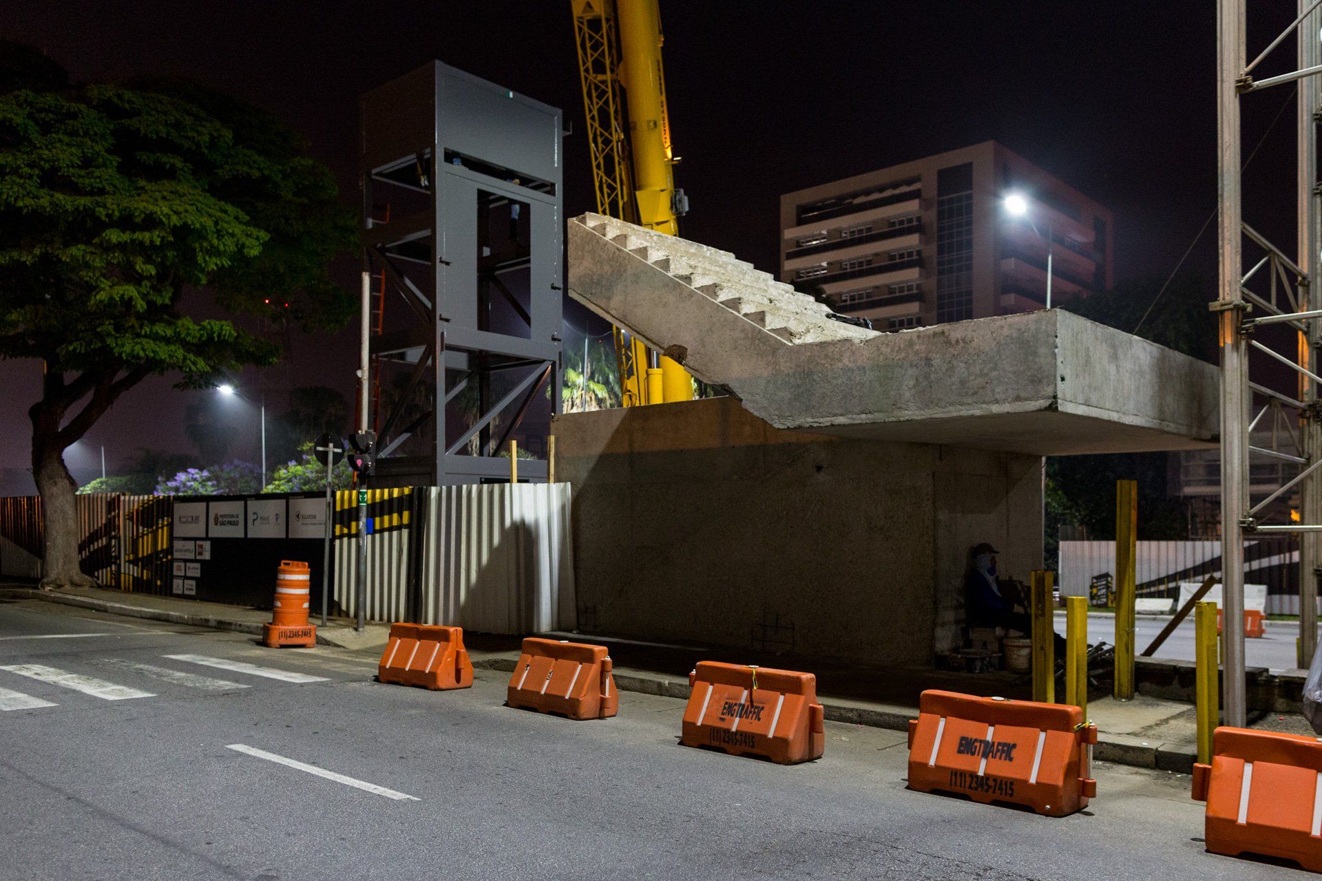 Uma estrutura de concreto está sendo construída na beira da estrada à noite