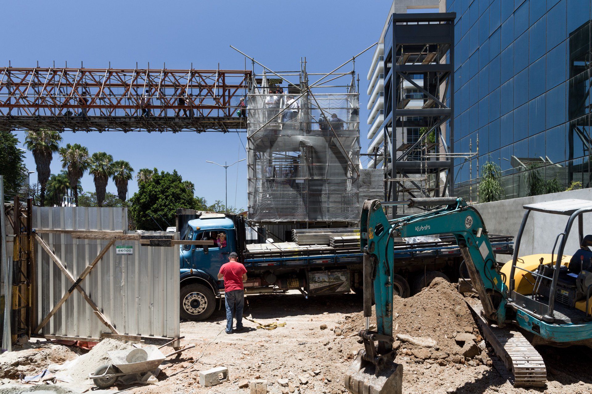 Um canteiro de obras com um caminhão azul e uma escavadeira azul