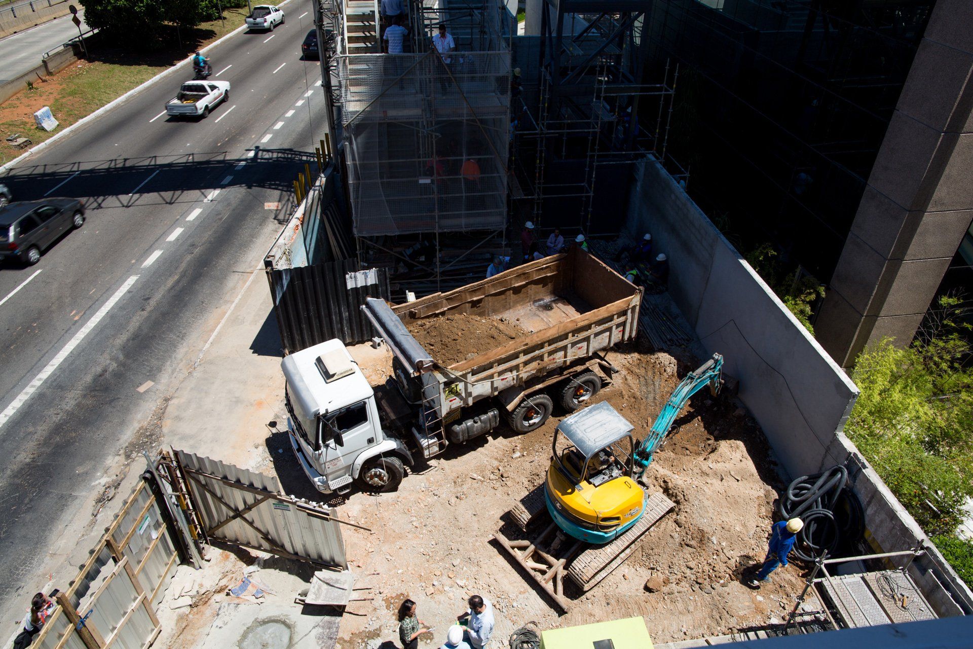 Uma vista aérea de um canteiro de obras com um caminhão e uma escavadeira