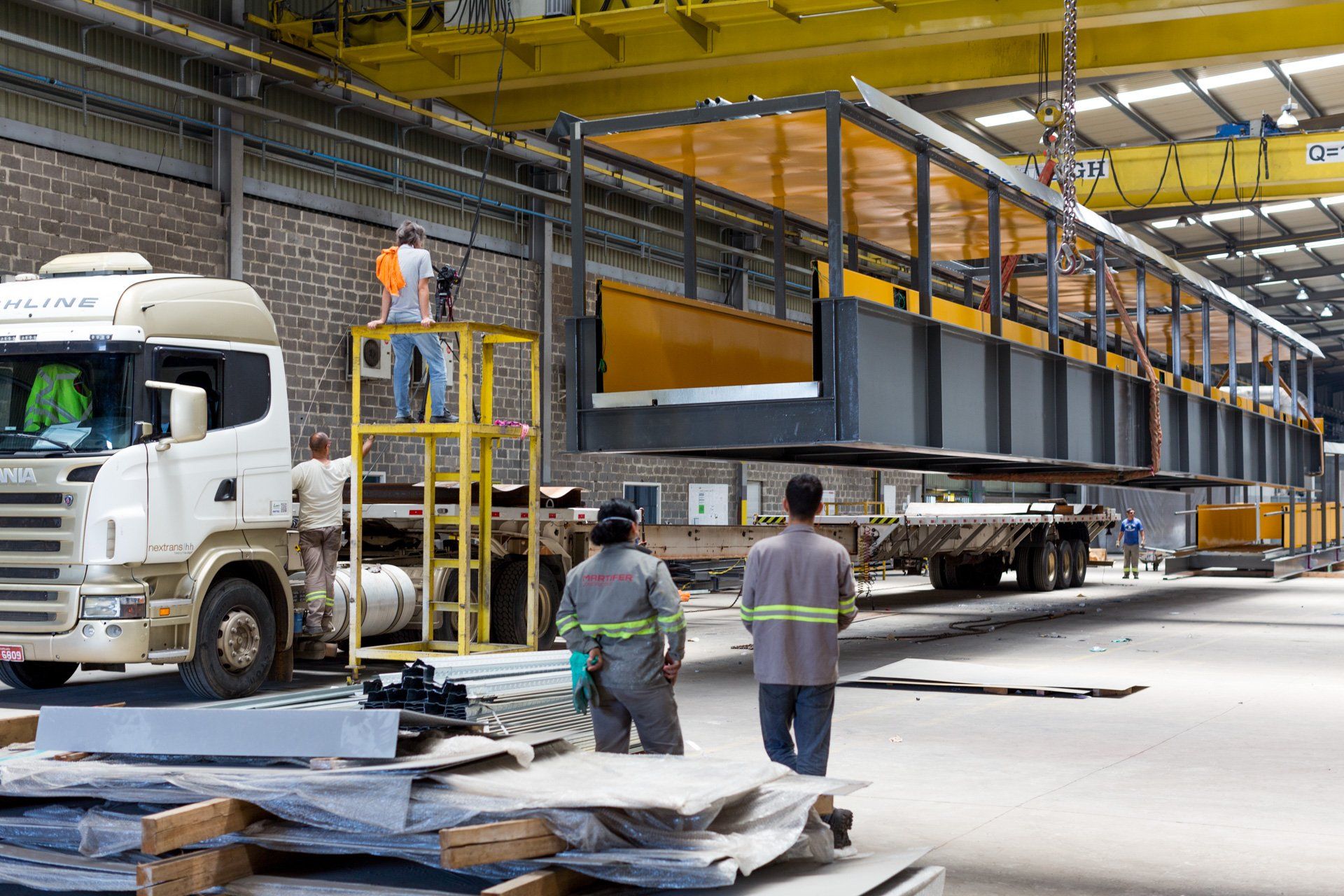 Um caminhão está sendo carregado por uma ponte em um armazém.