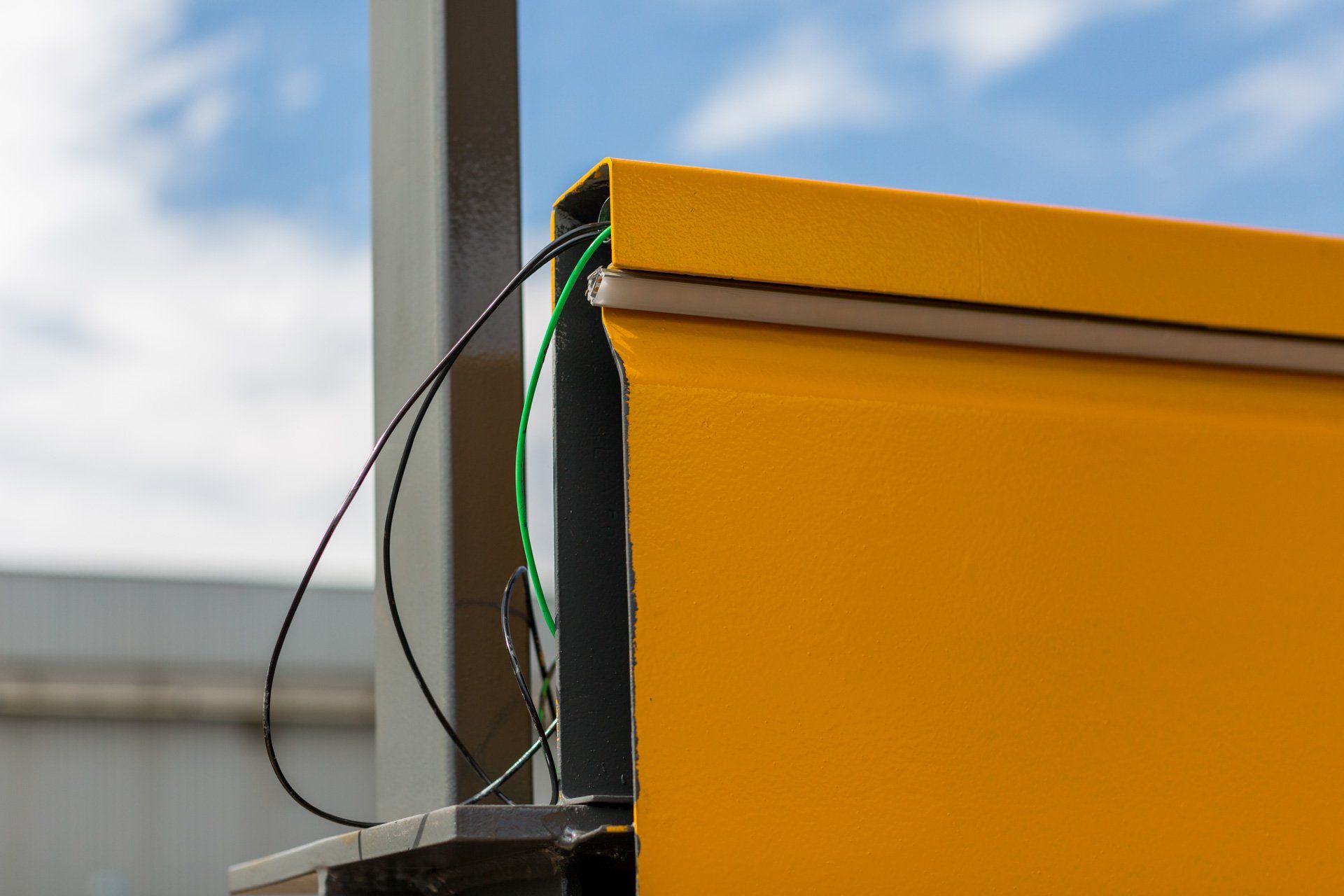 Uma caixa amarela com um cabo verde conectado a ela.