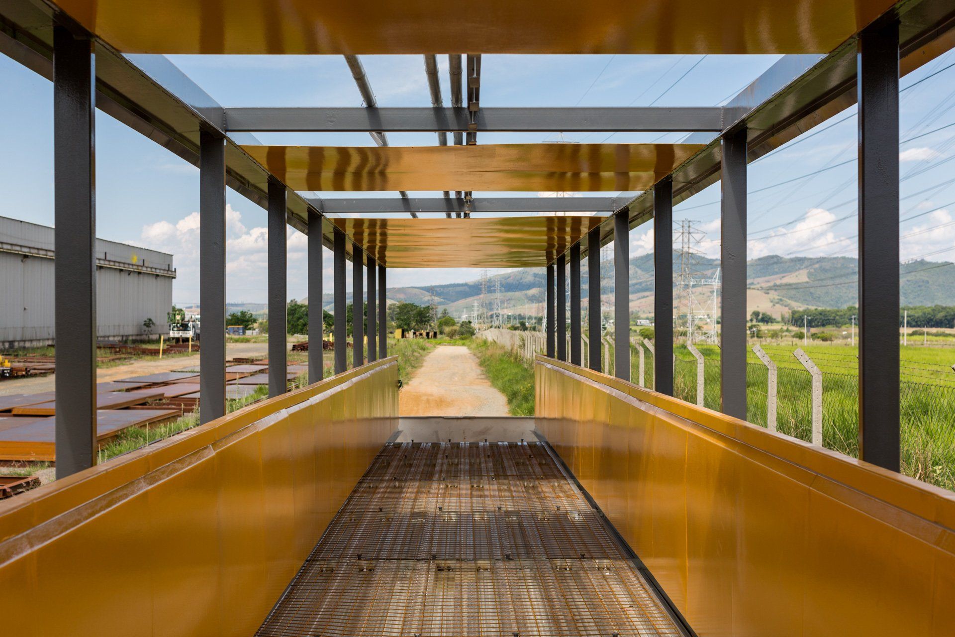 Uma longa passarela com muitas janelas que levam a um campo.