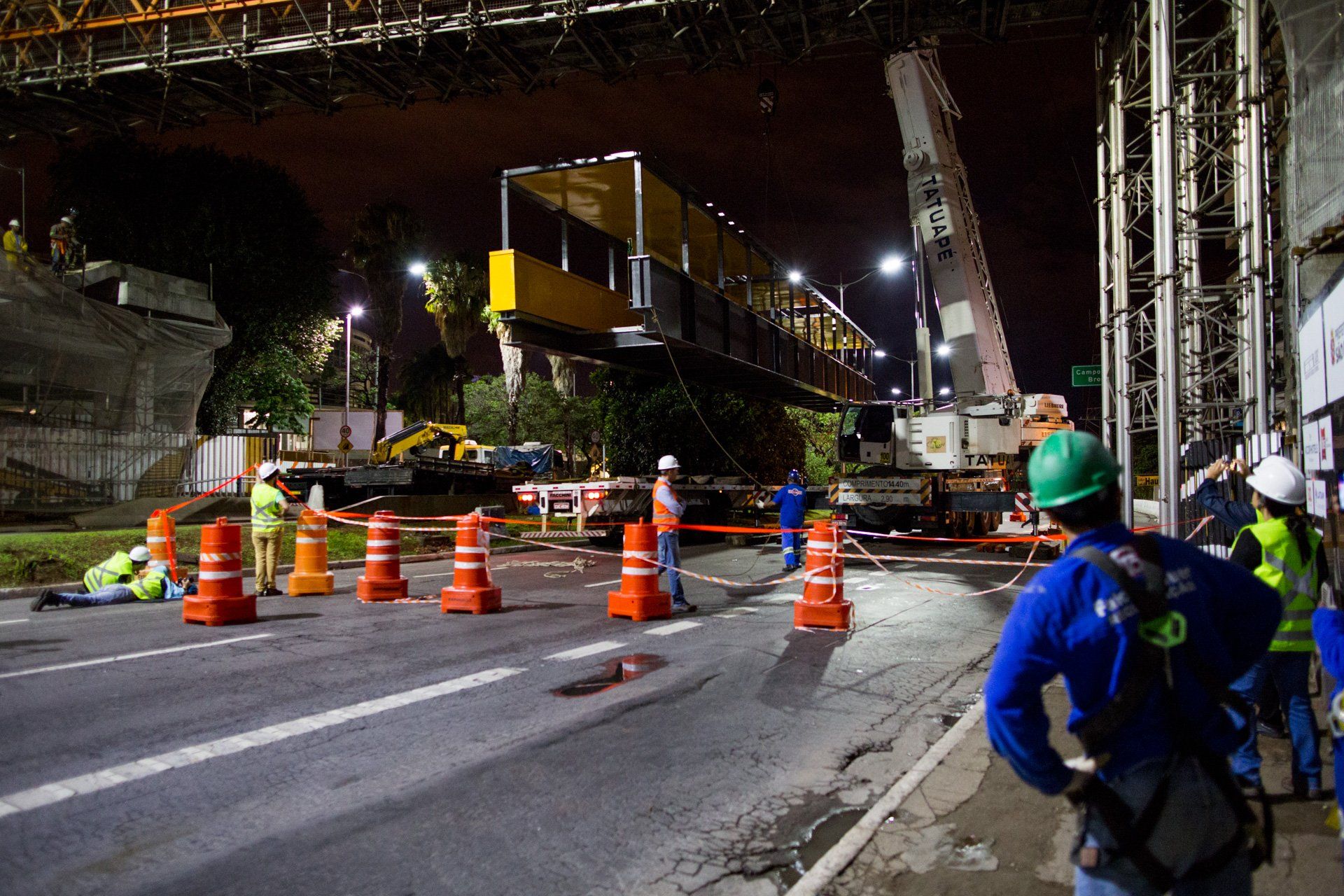 Um grupo de trabalhadores da construção civil está trabalhando em uma ponte à noite