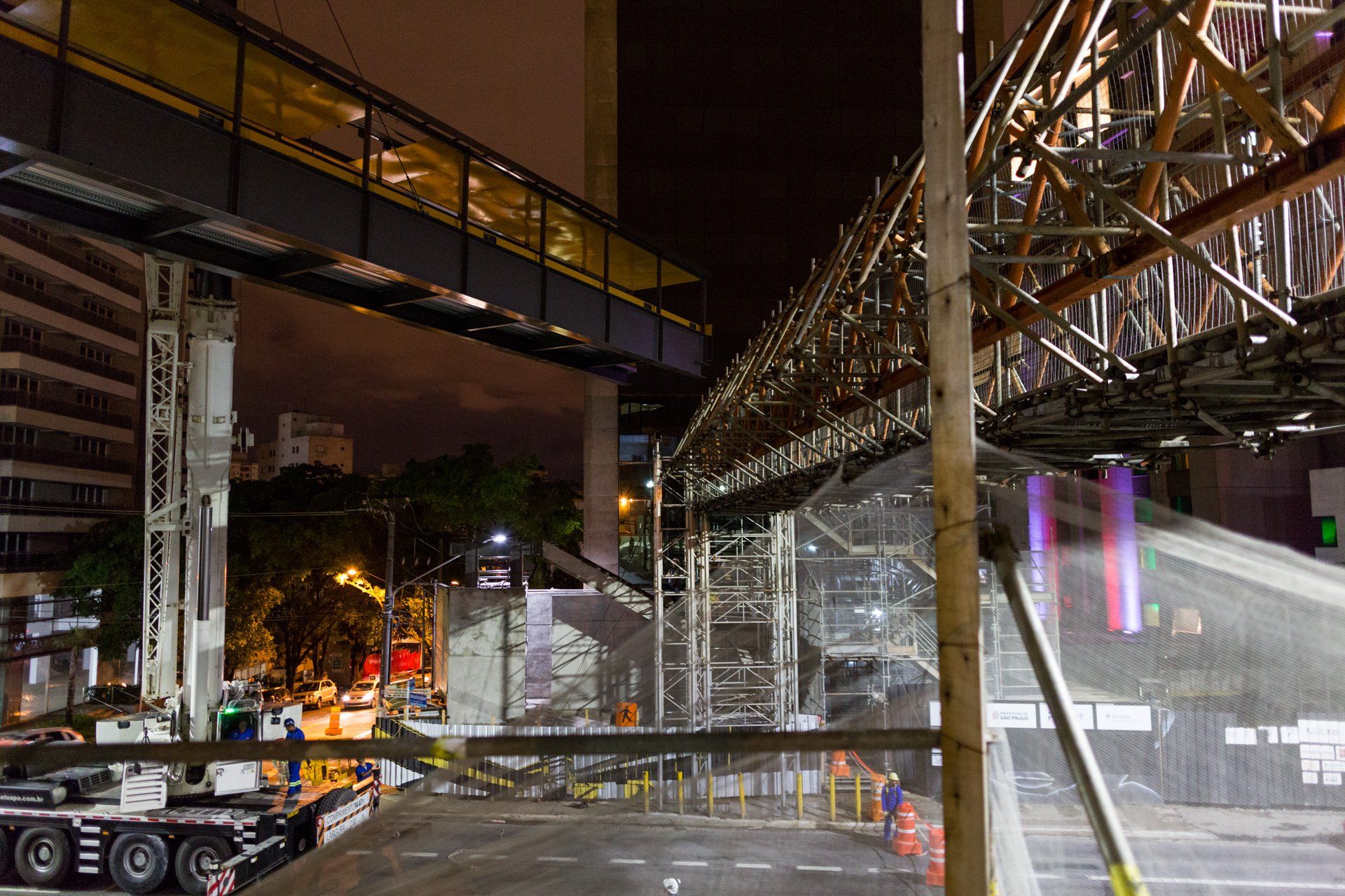 Uma ponte está sendo construída sobre uma rua da cidade à noite.