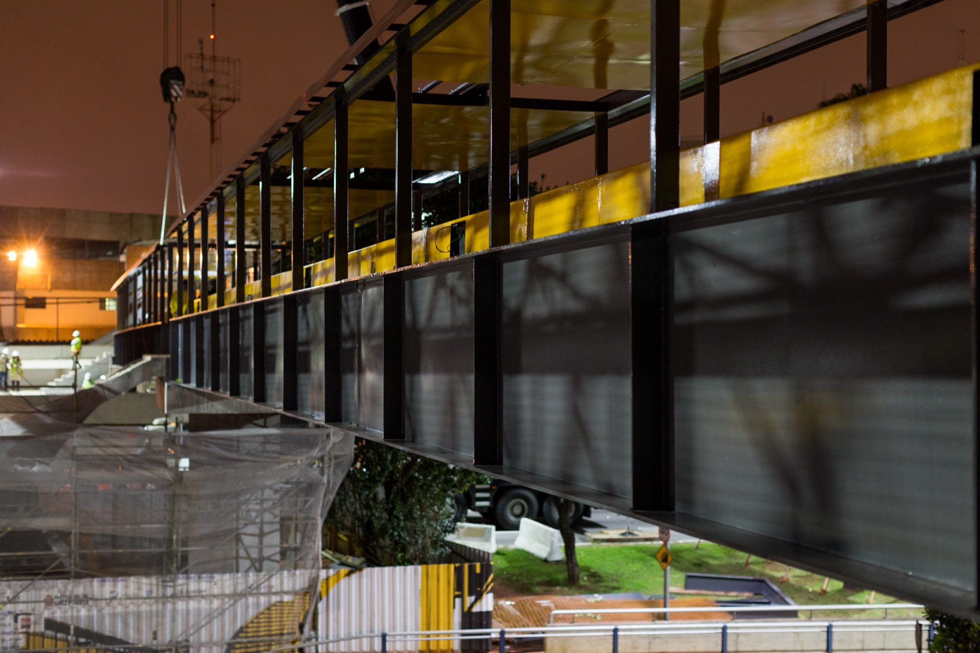 Uma grande ponte metálica está sendo construída à noite.