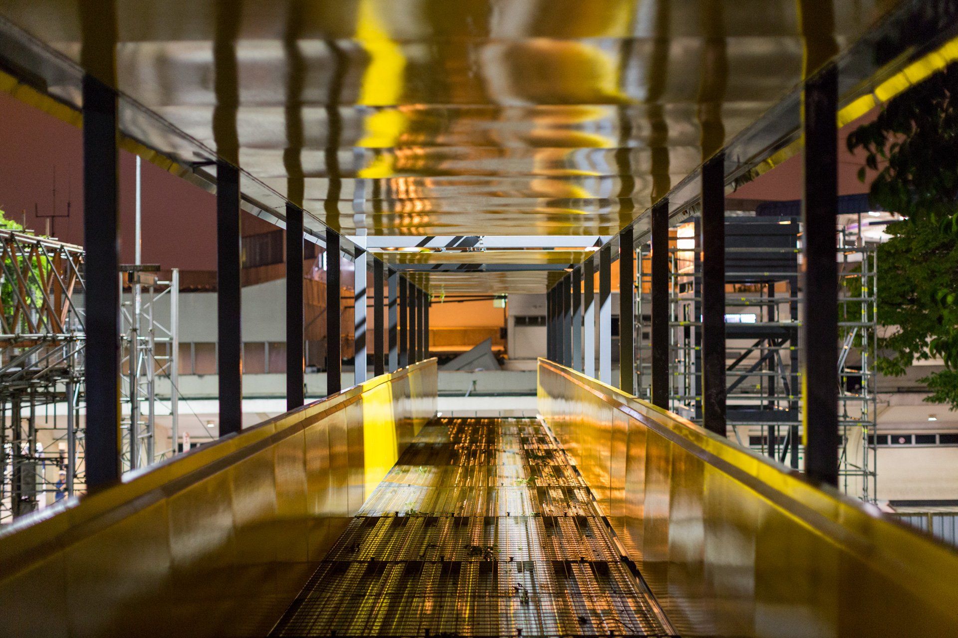 Um longo corredor com o reflexo de um prédio no teto.