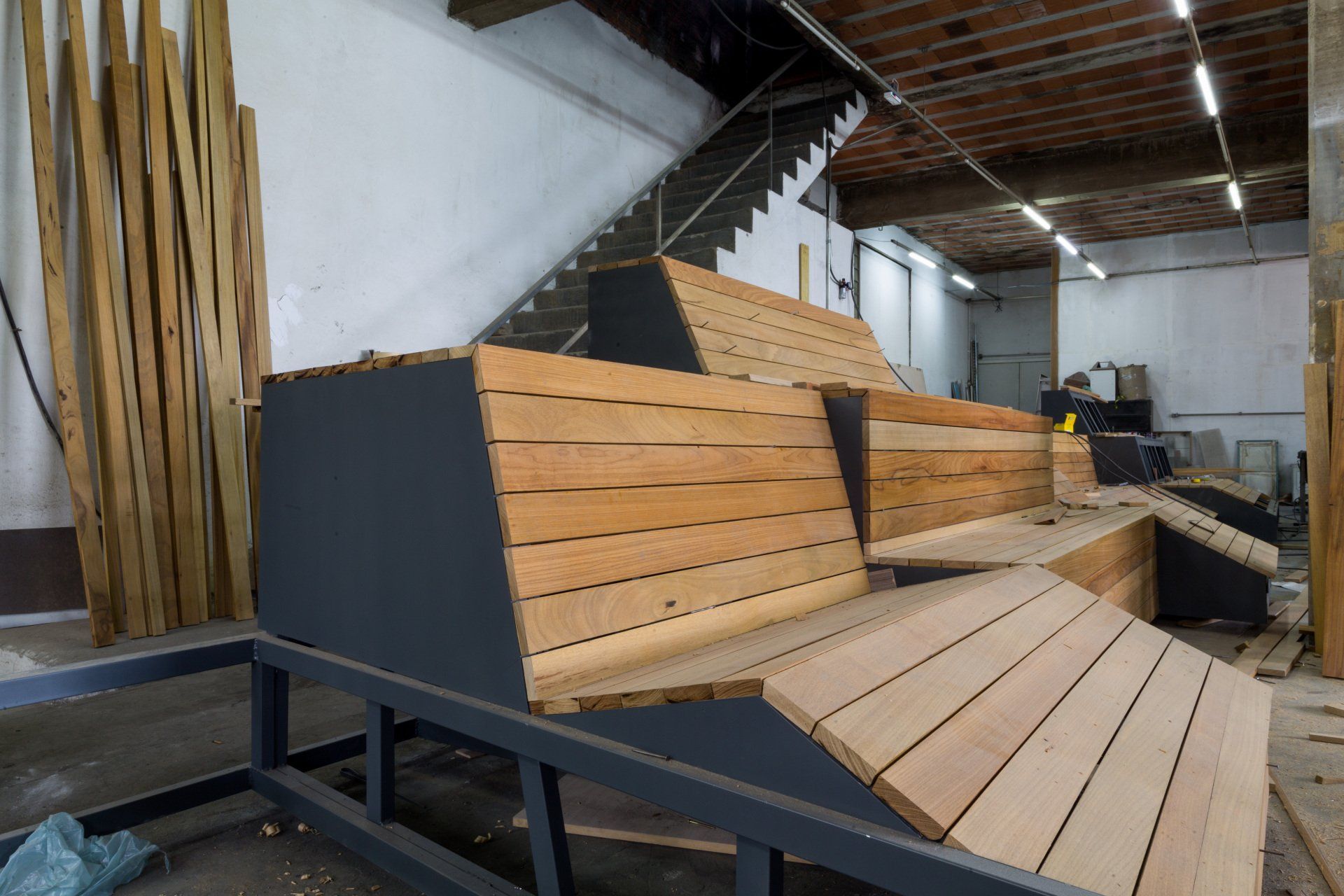 Um banco de madeira está em um armazém próximo às escadas.