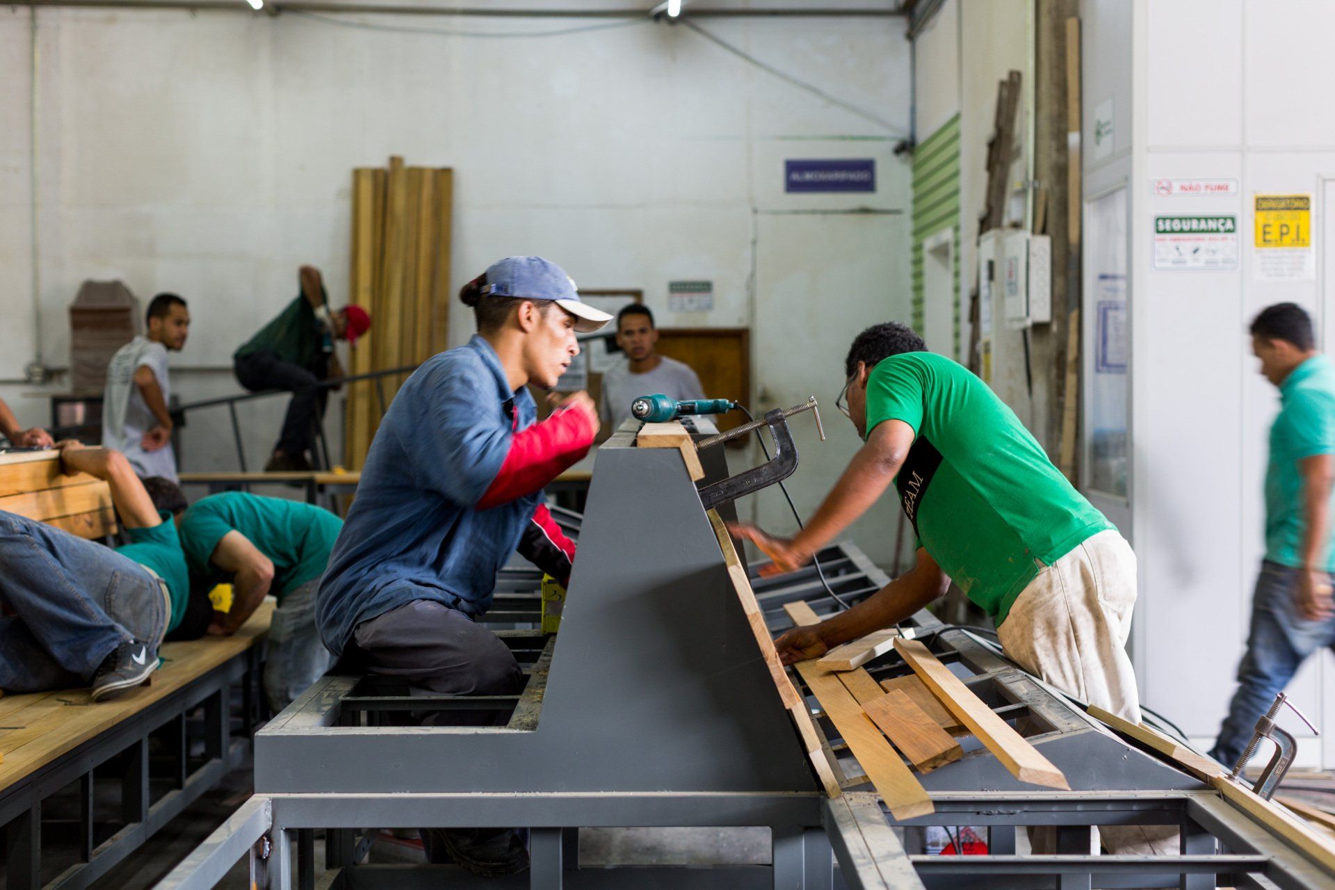 Um grupo de homens trabalha em uma máquina em uma fábrica.