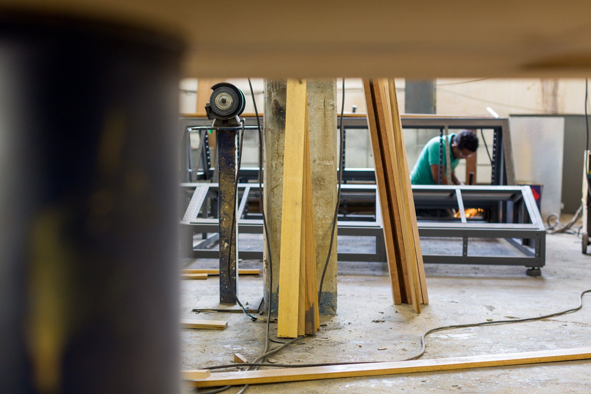 Um homem está trabalhando em um pedaço de metal em uma fábrica.