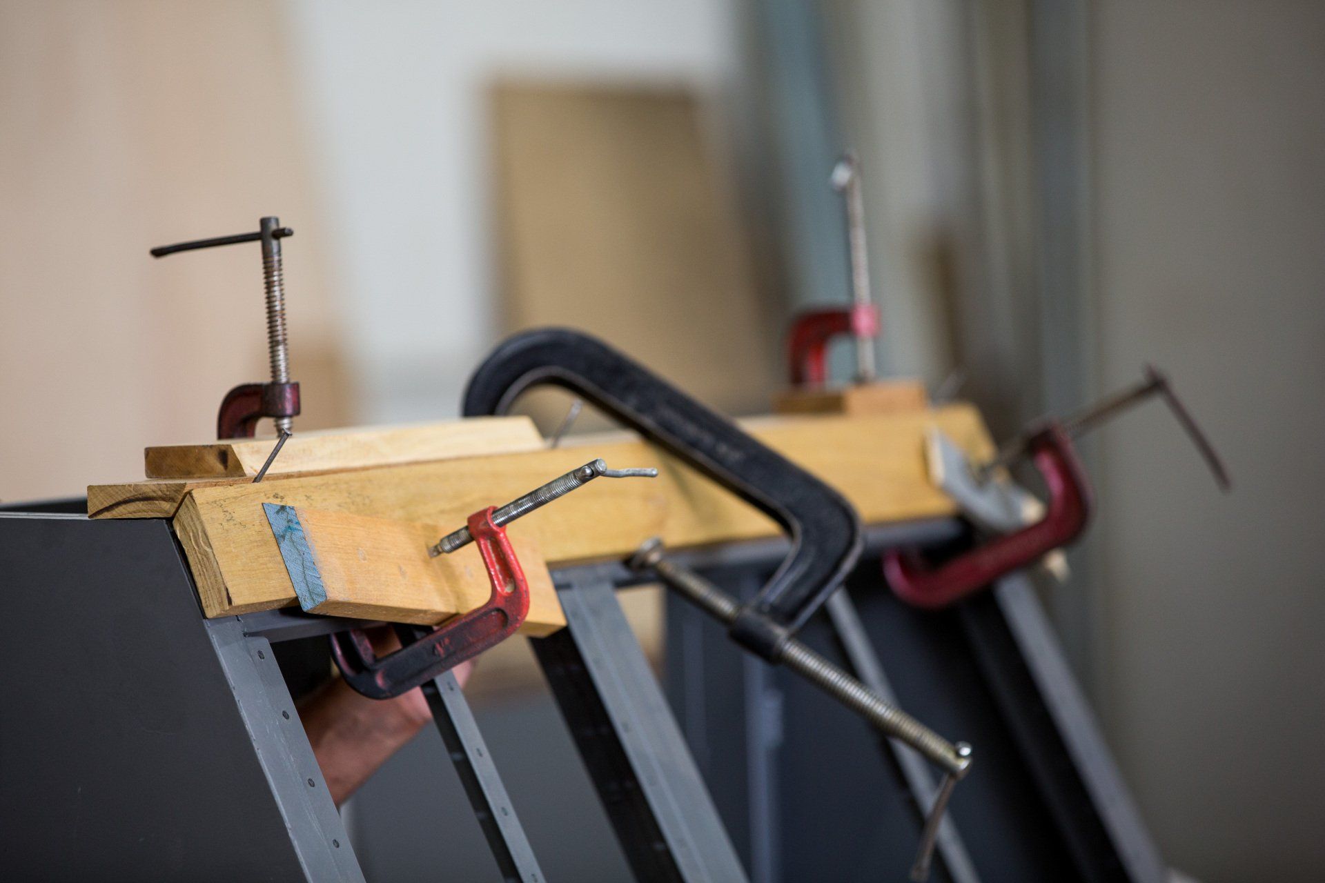 Uma pessoa está usando uma pinça em um pedaço de madeira.