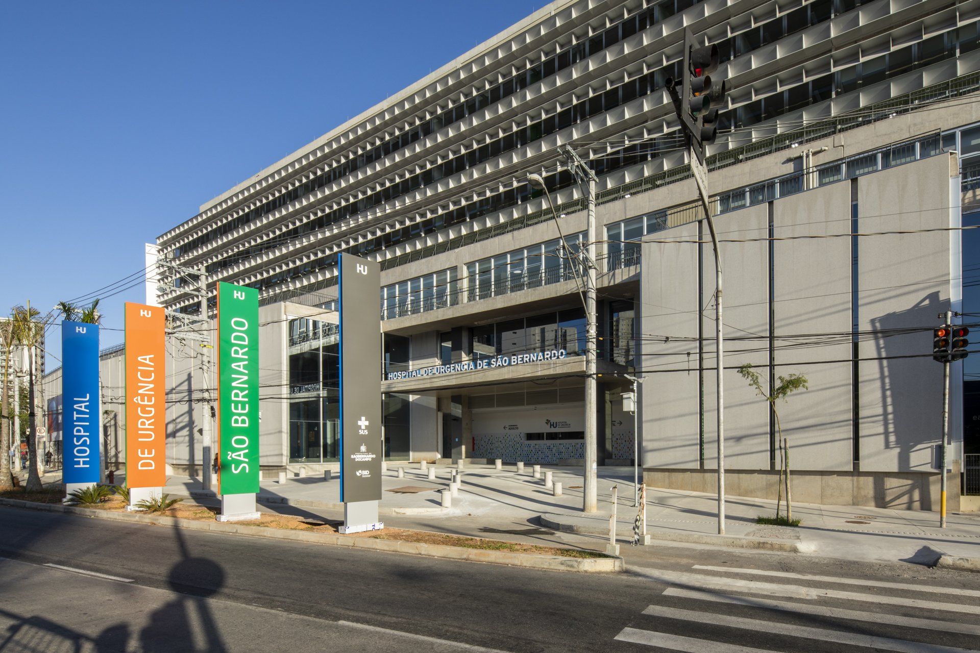 Um grande edifício com muitas janelas fica próximo a uma rua.