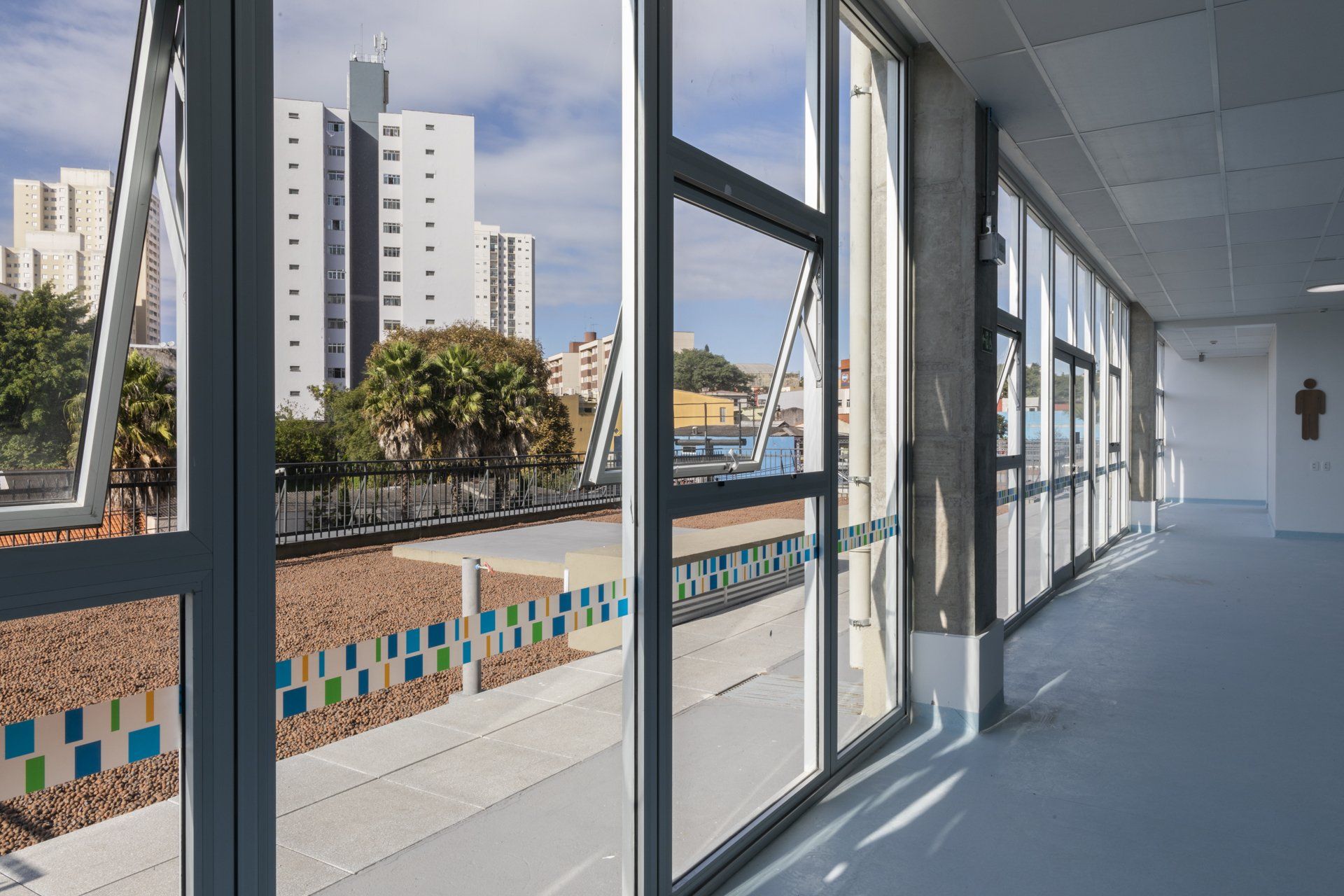 Um corredor com muitas janelas e vista para a cidade