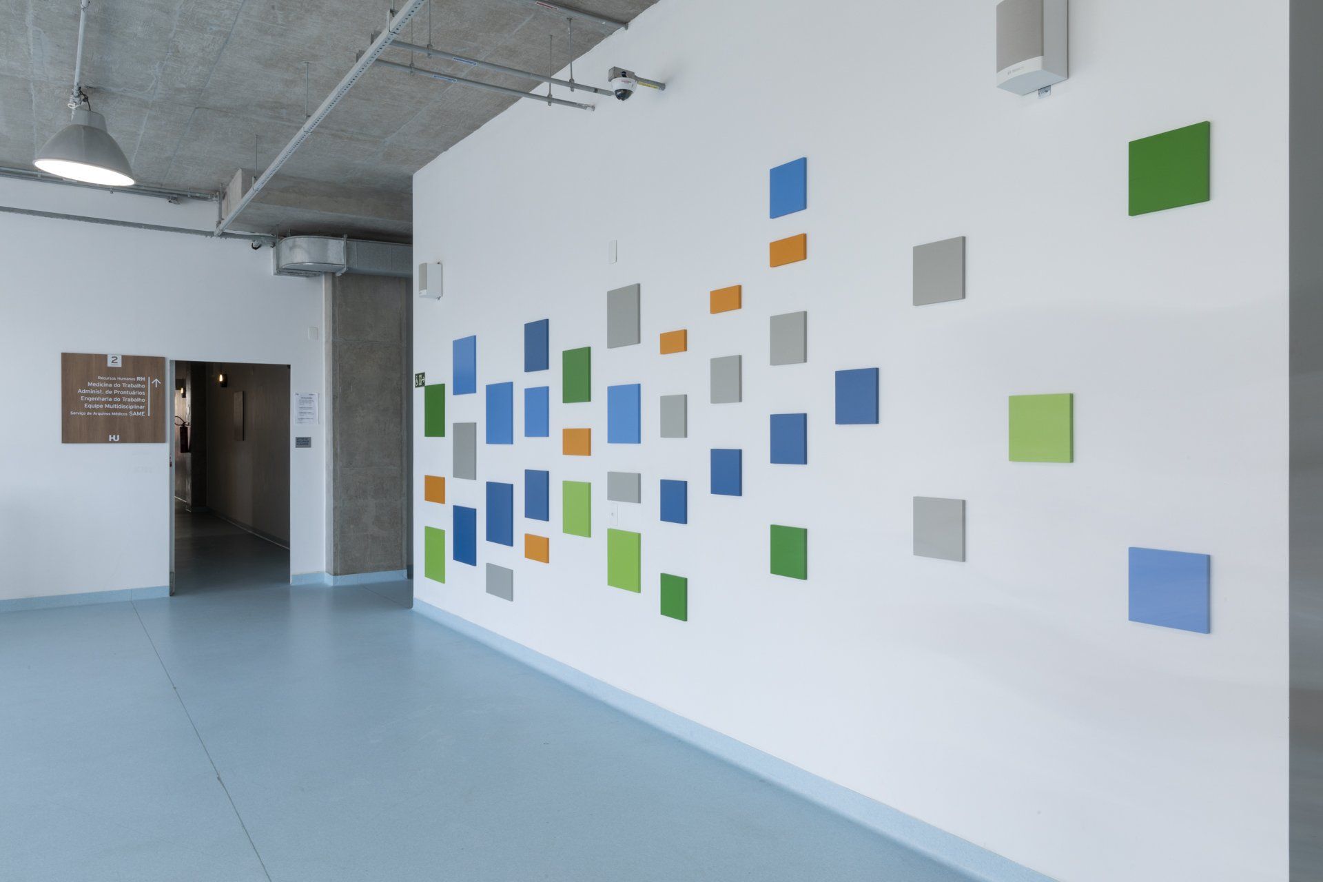 Um corredor com uma parede branca e quadrados coloridos
