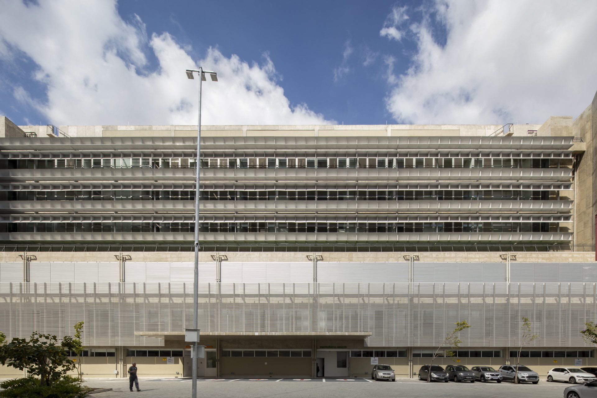 Um grande edifício com carros estacionados em frente