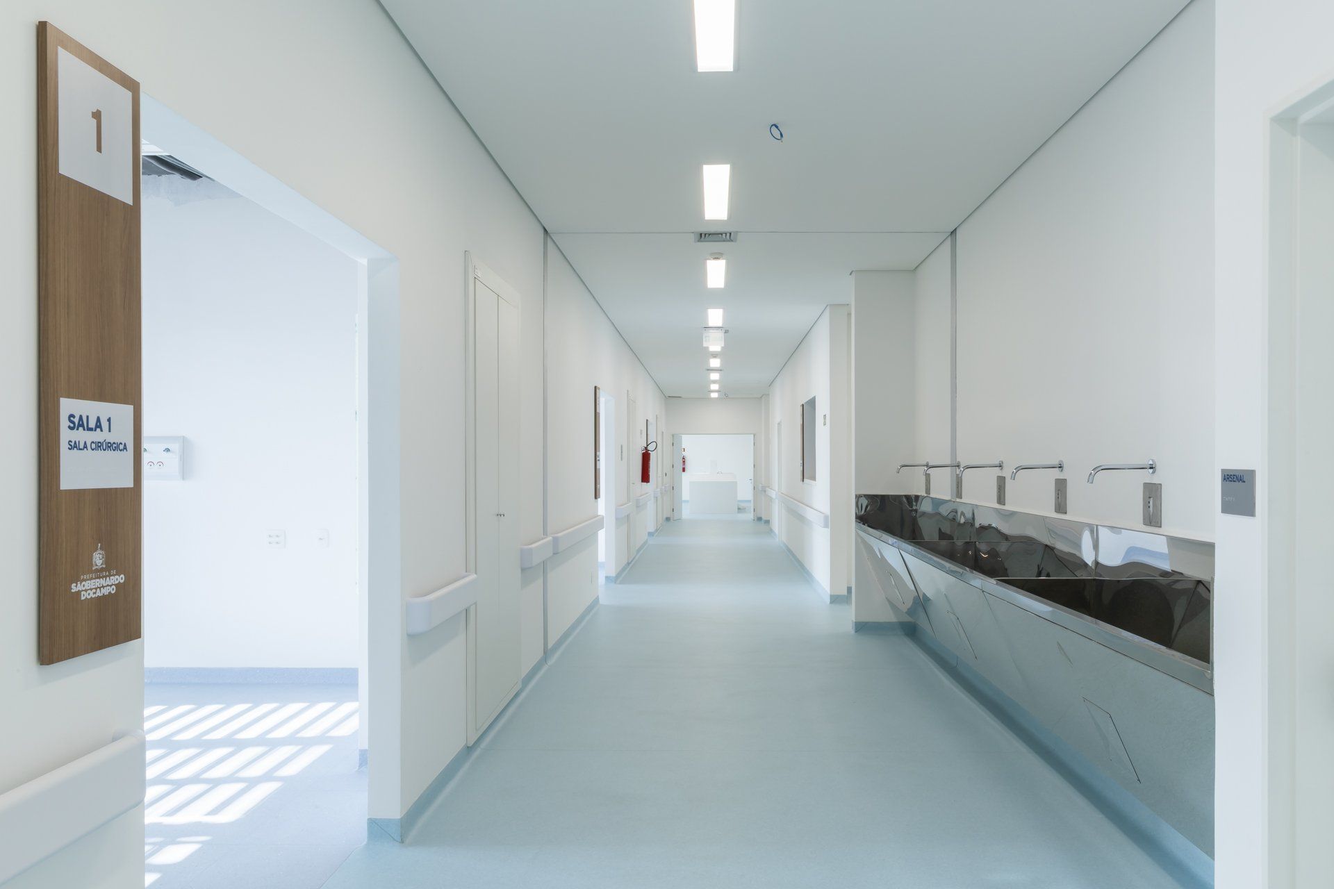 Um corredor de hospital vazio com uma pia no meio