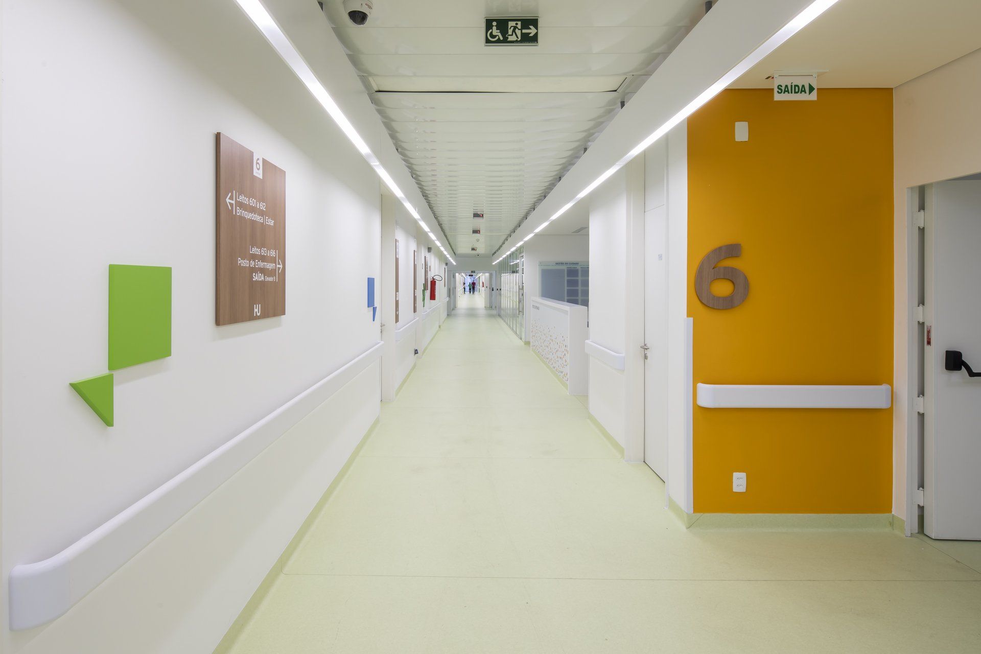 Um longo corredor de um hospital com o número 6 na parede.