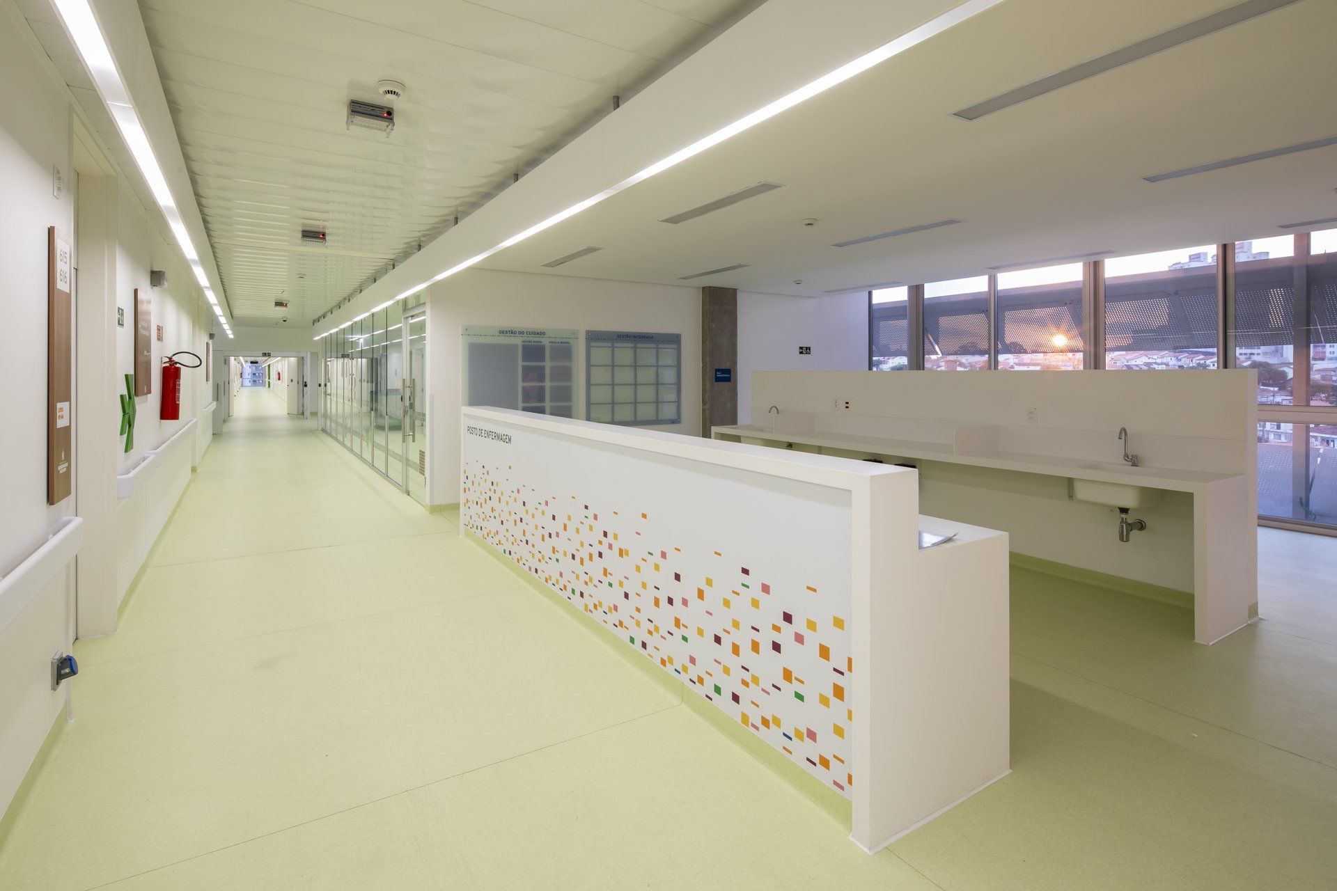 Um longo corredor de um hospital com balcão e pia.