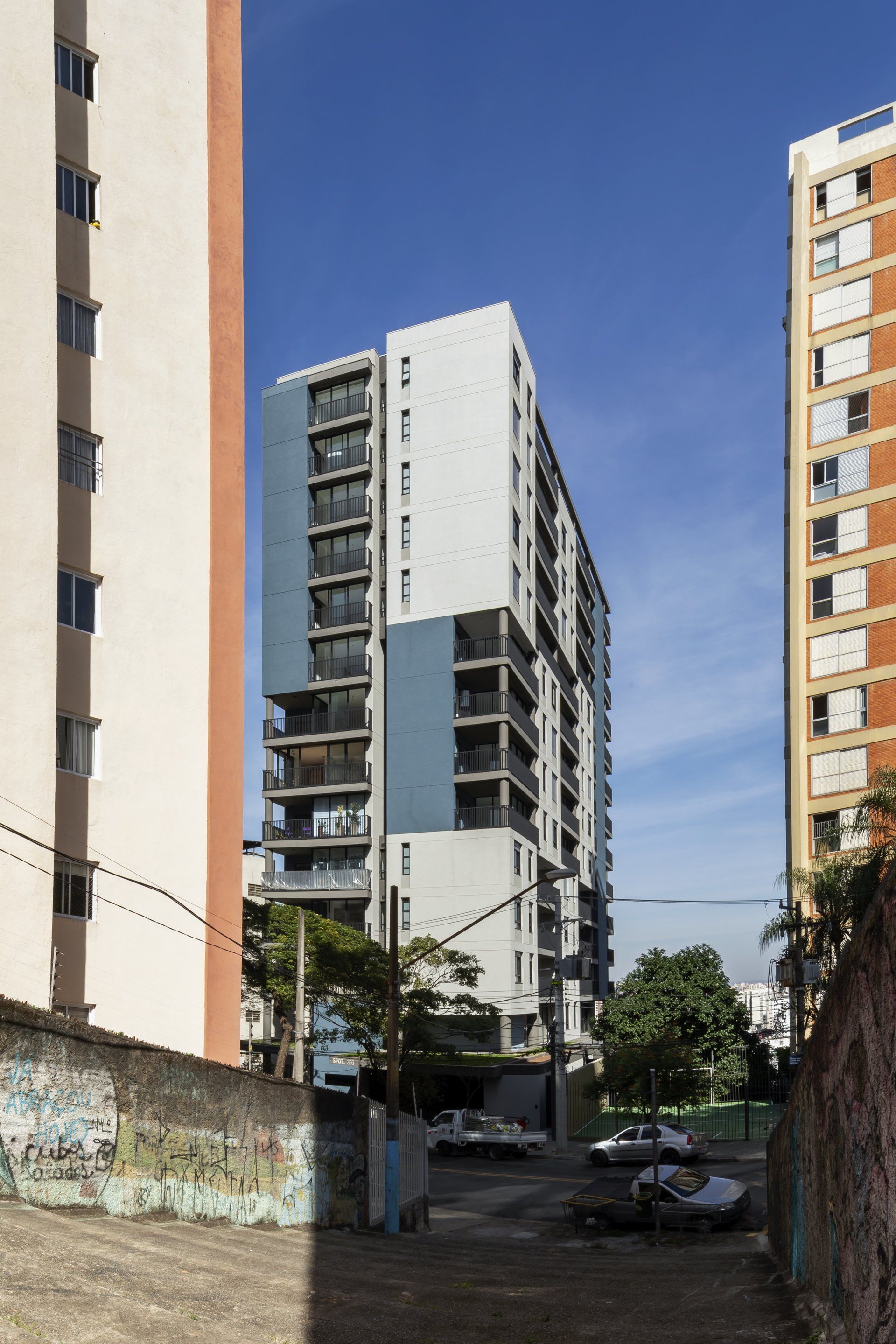 Um prédio com muitas janelas está cercado por outros edifícios