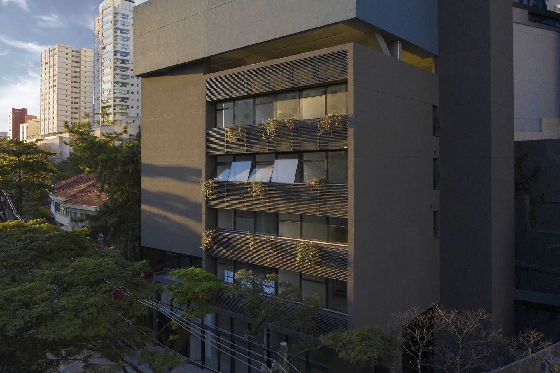 Um grande edifício com muitas janelas é cercado por árvores.