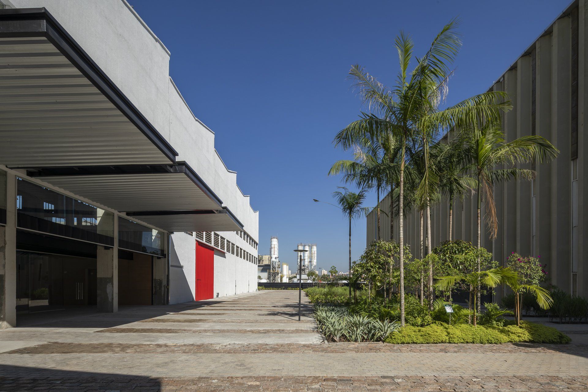 Um grande edifício com uma porta vermelha é cercado por árvores.