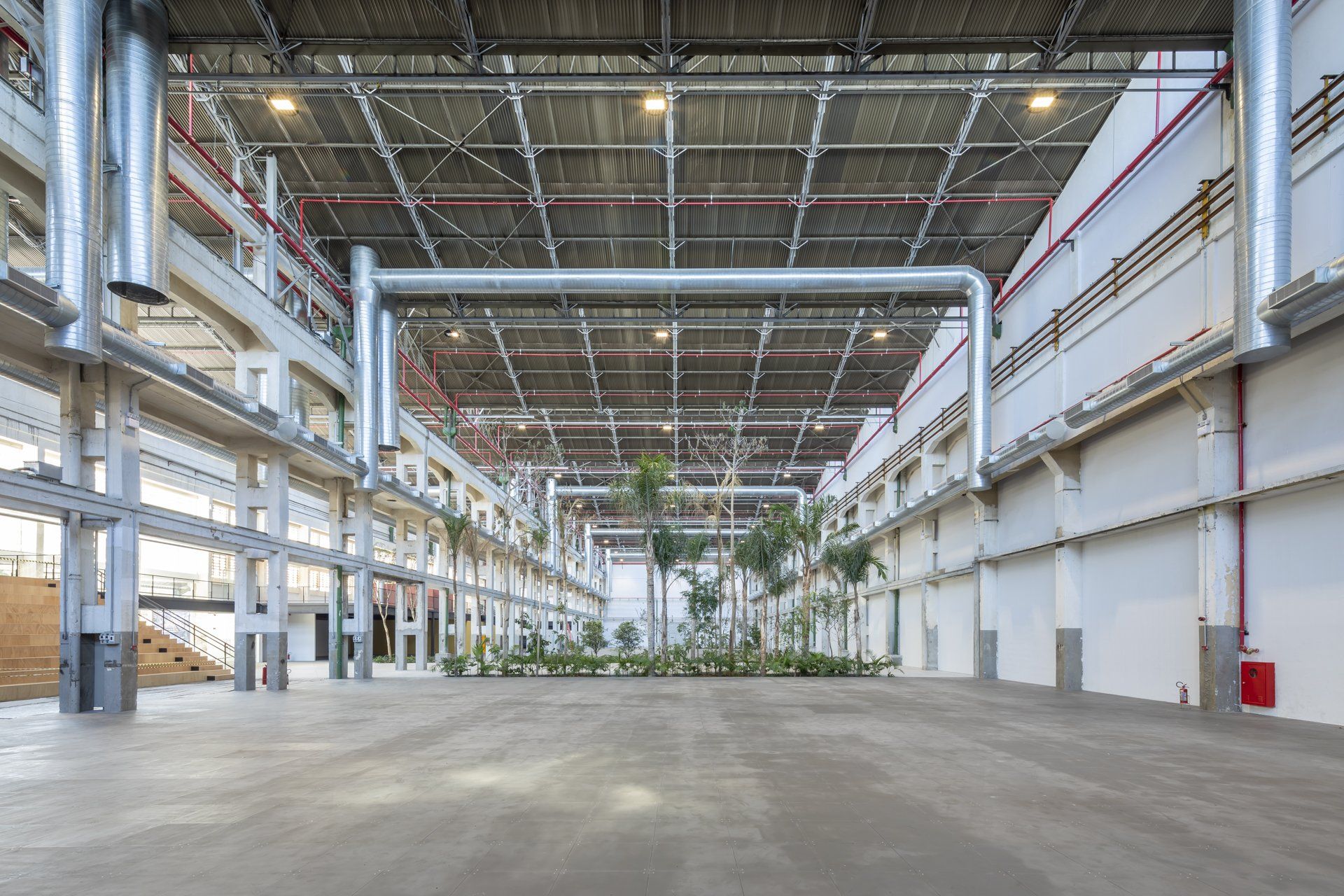 Um grande armazém vazio com muitos canos saindo do teto.