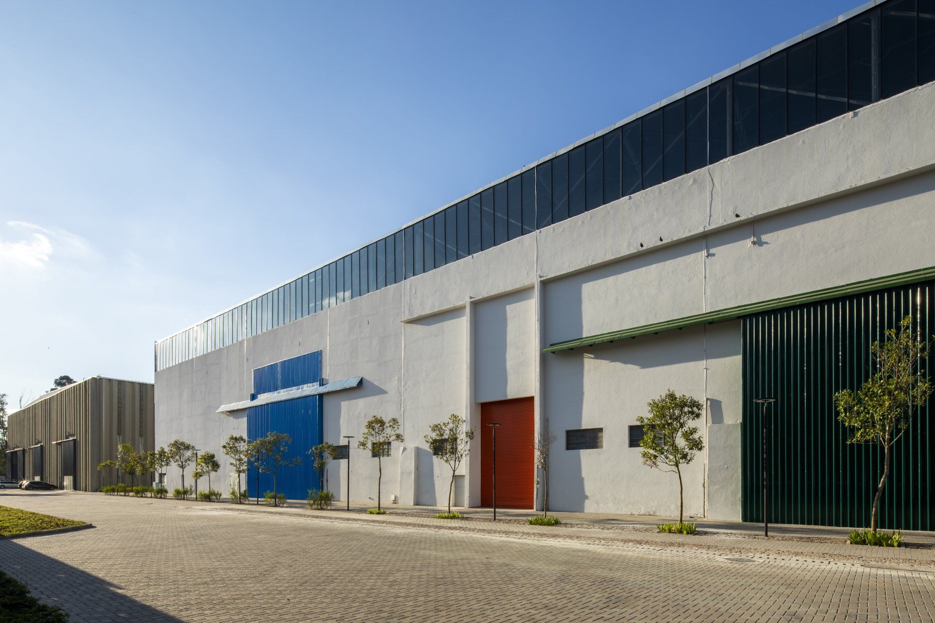 Uma fileira de armazéns está alinhada um ao lado do outro em um dia ensolarado.