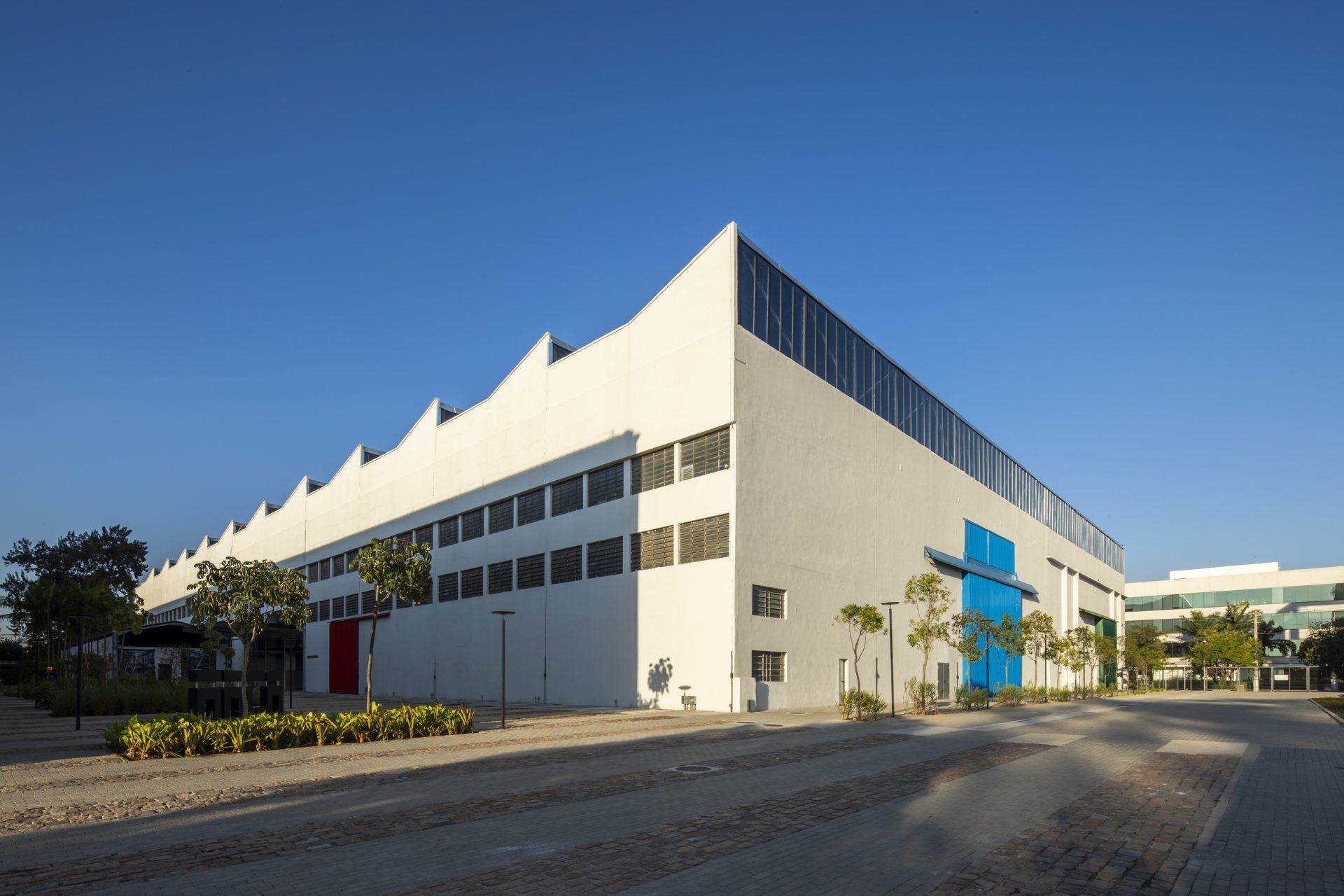 Um grande edifício branco com uma faixa azul e vermelha na lateral