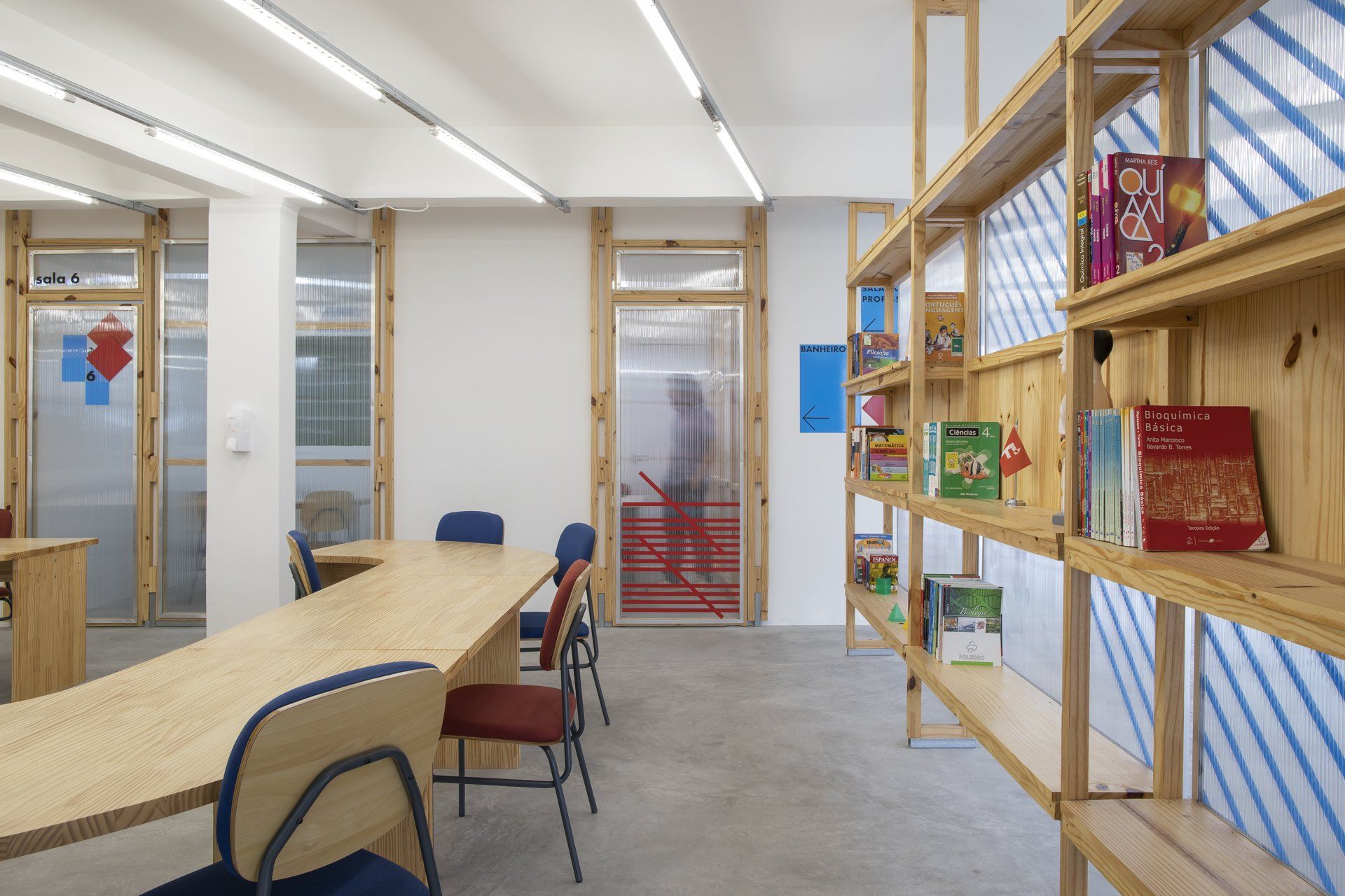 Uma sala com mesa e cadeiras e estantes cheias de livros.