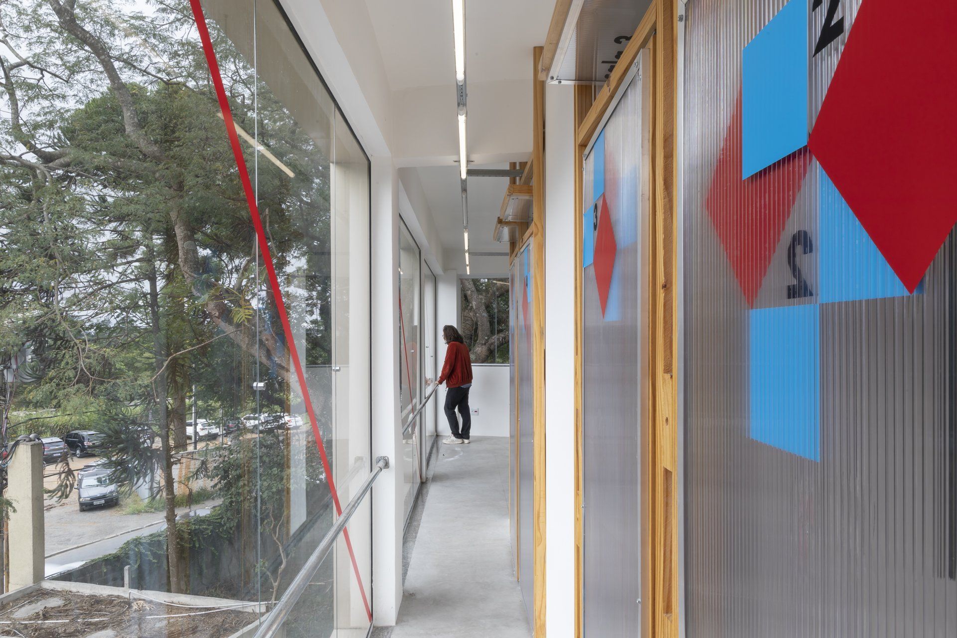 Uma pessoa está andando pelo corredor de um prédio.