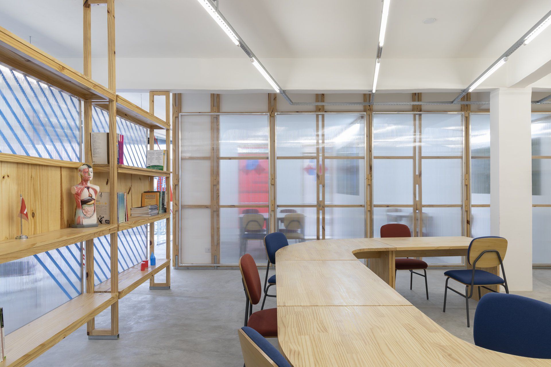 Uma sala com uma longa mesa e cadeiras.