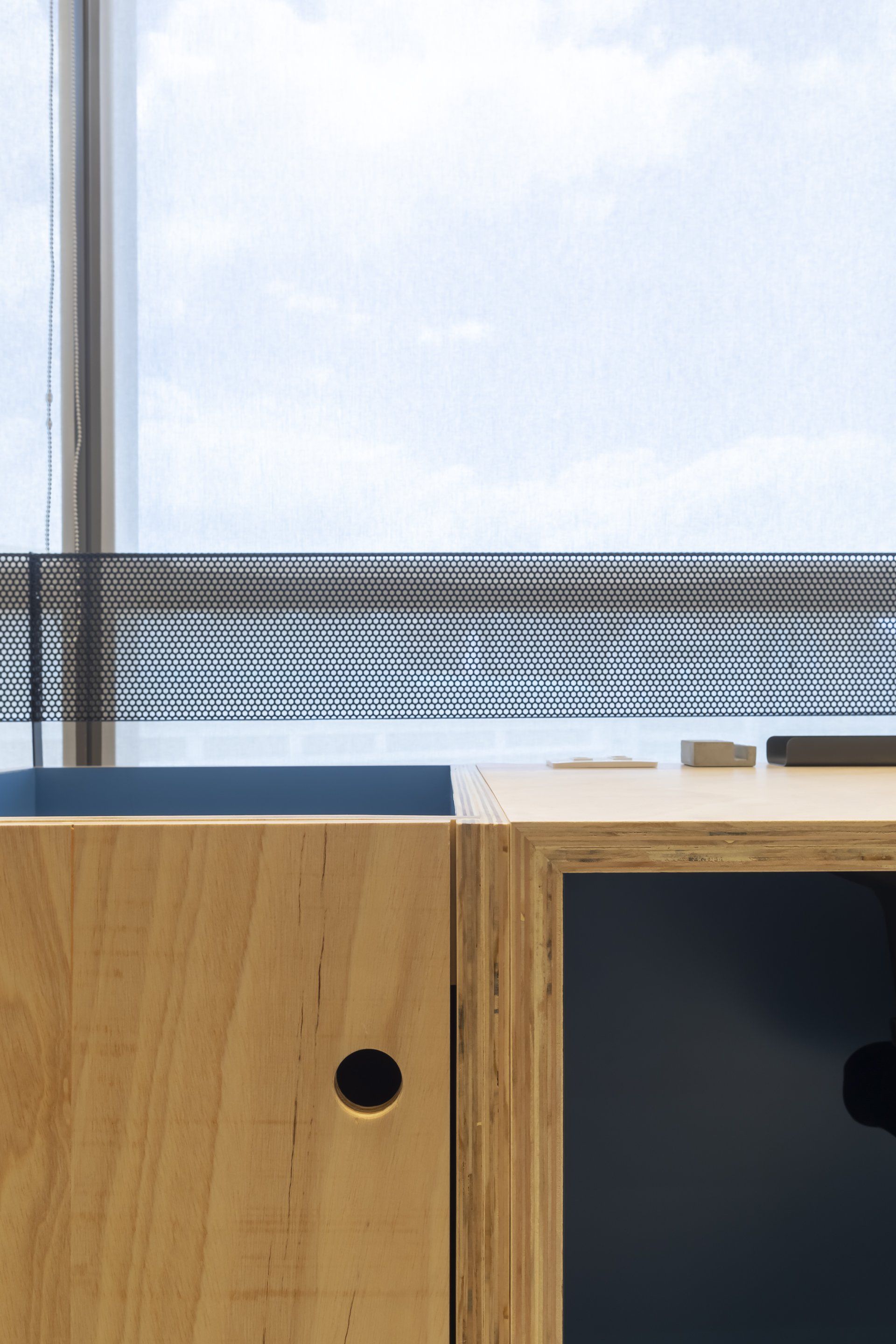 Um close de um armário de madeira com uma janela ao fundo.