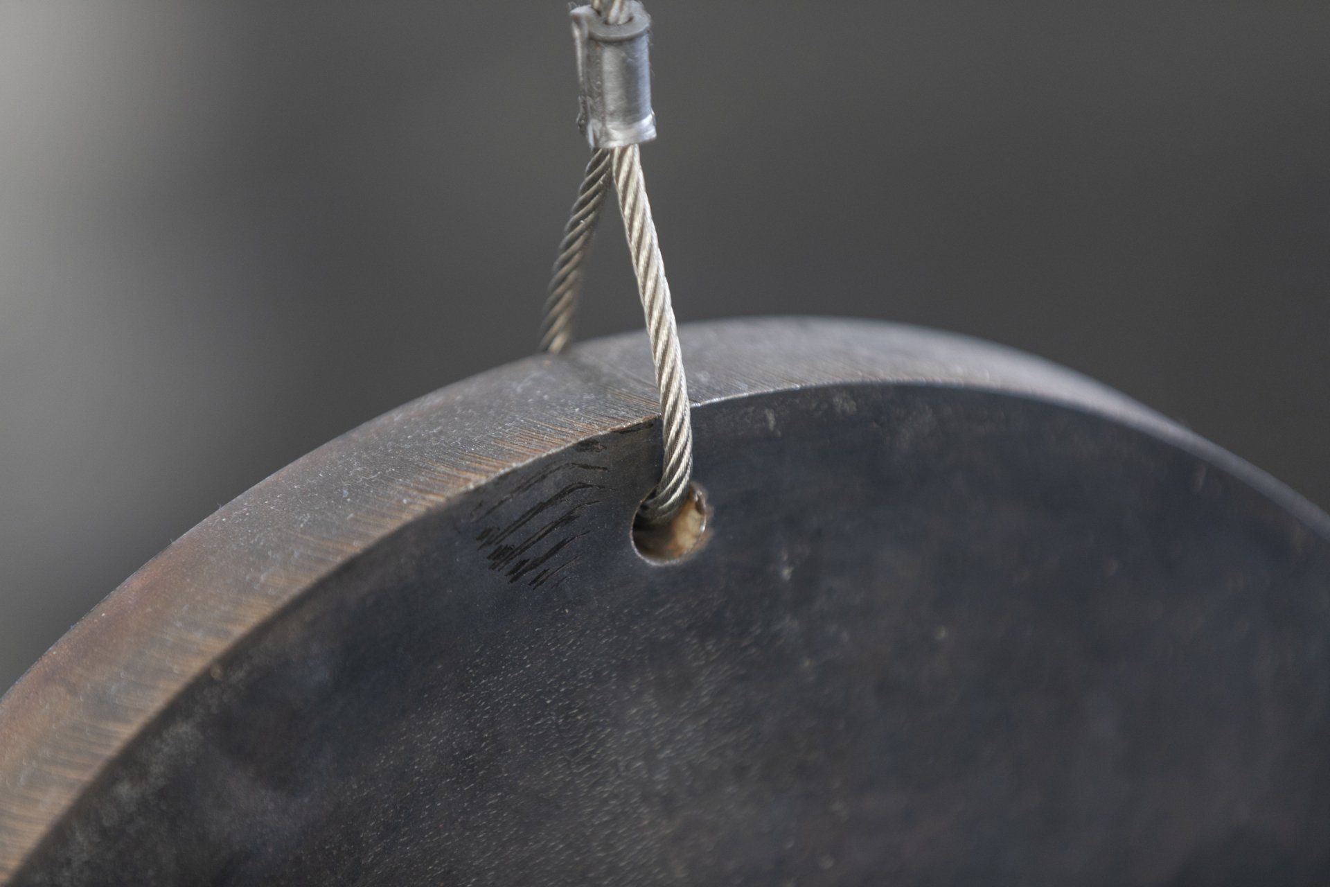 Um close de um objeto de metal com uma corda pendurada nele.