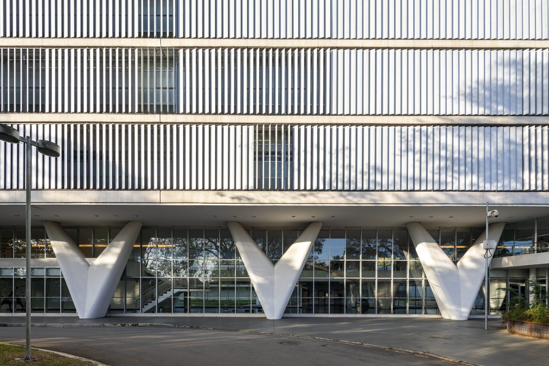 Um grande edifício branco com muitas janelas e muitas colunas.