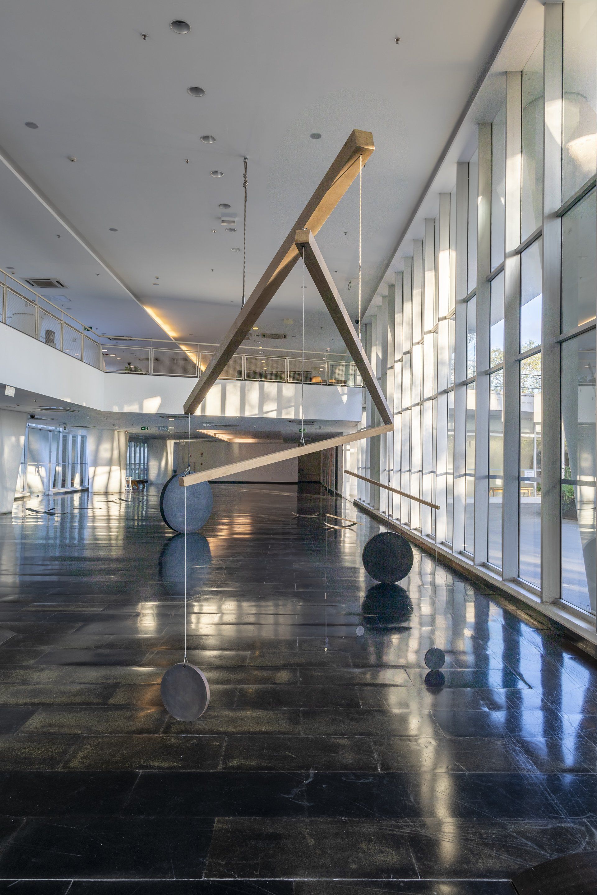 Uma grande escultura está pendurada no teto de um edifício.