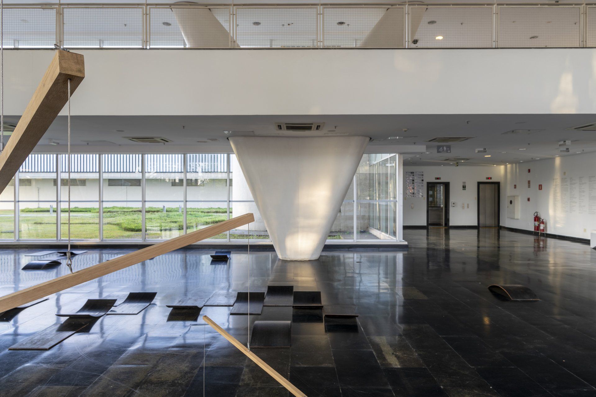 Uma grande sala vazia com uma escada no meio.