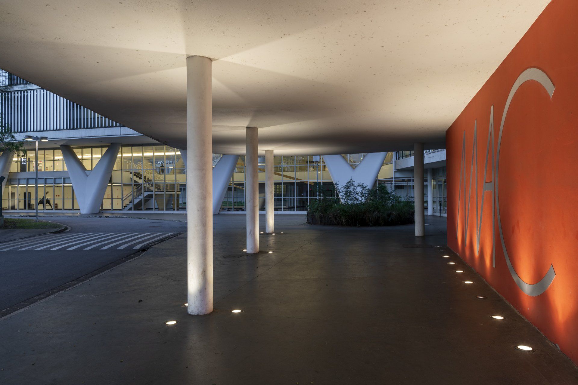 Um grande edifício com uma parede vermelha e colunas.