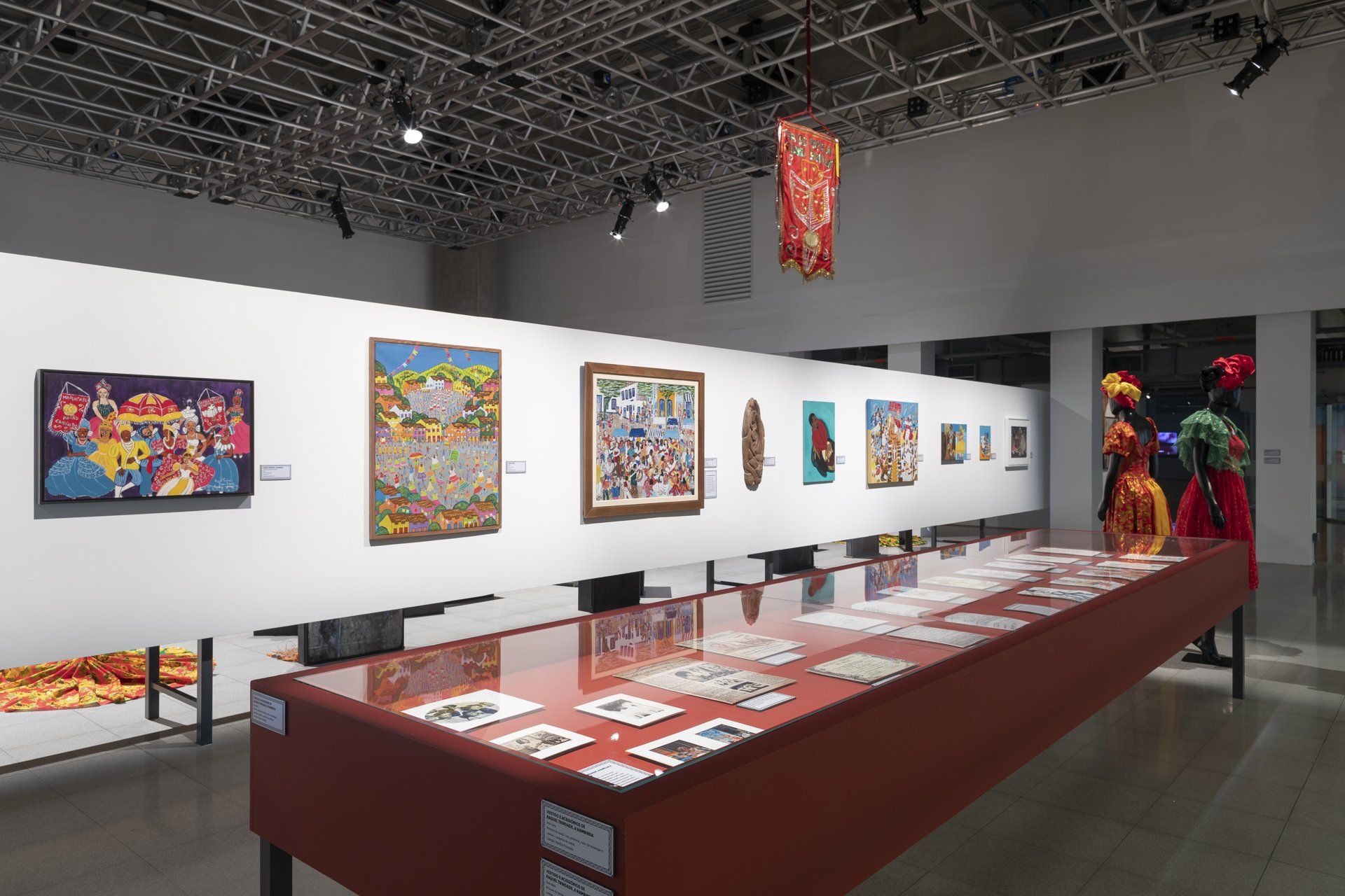 Uma longa mesa em um museu com pinturas na parede.