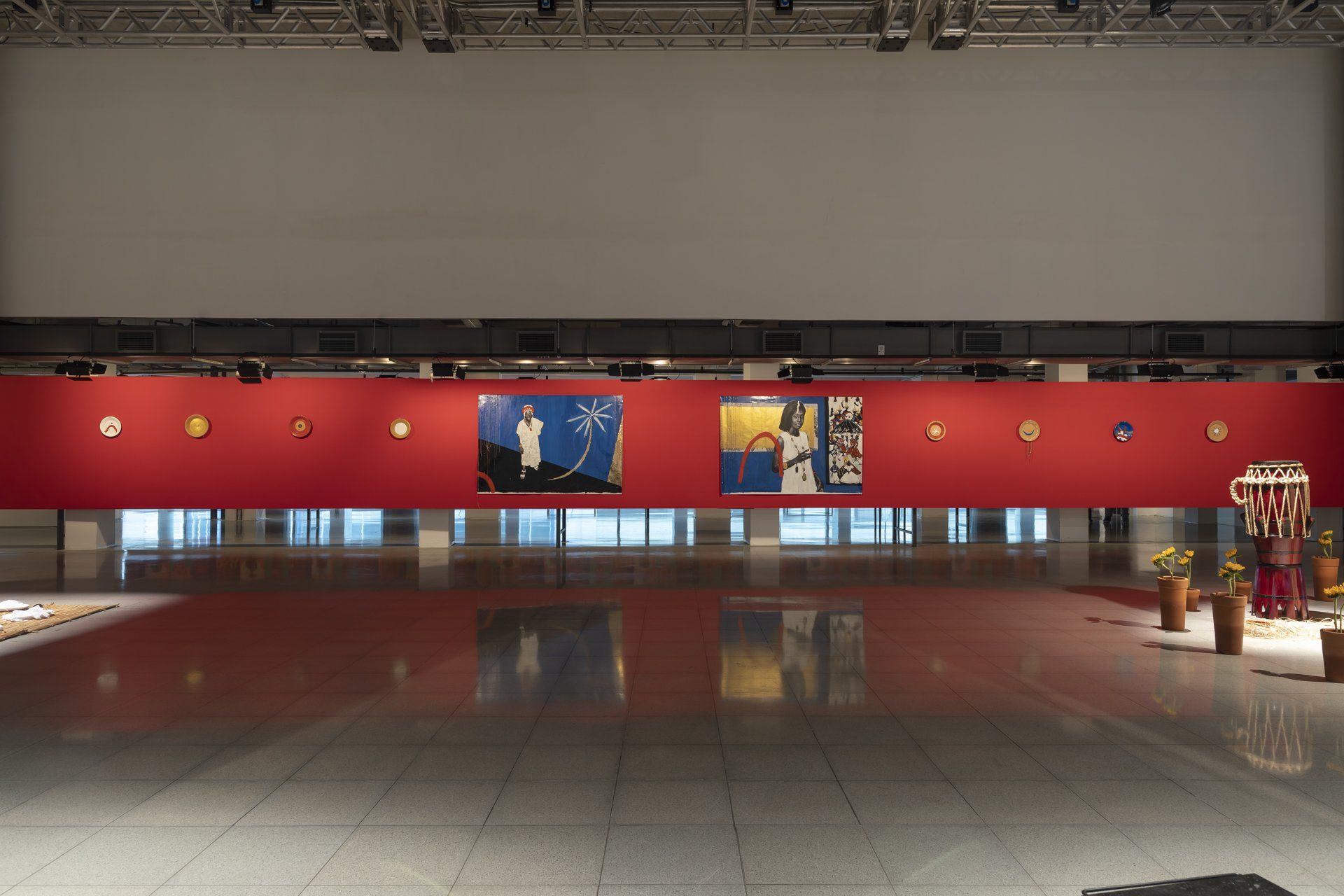 Uma grande sala vazia com uma parede vermelha e pinturas