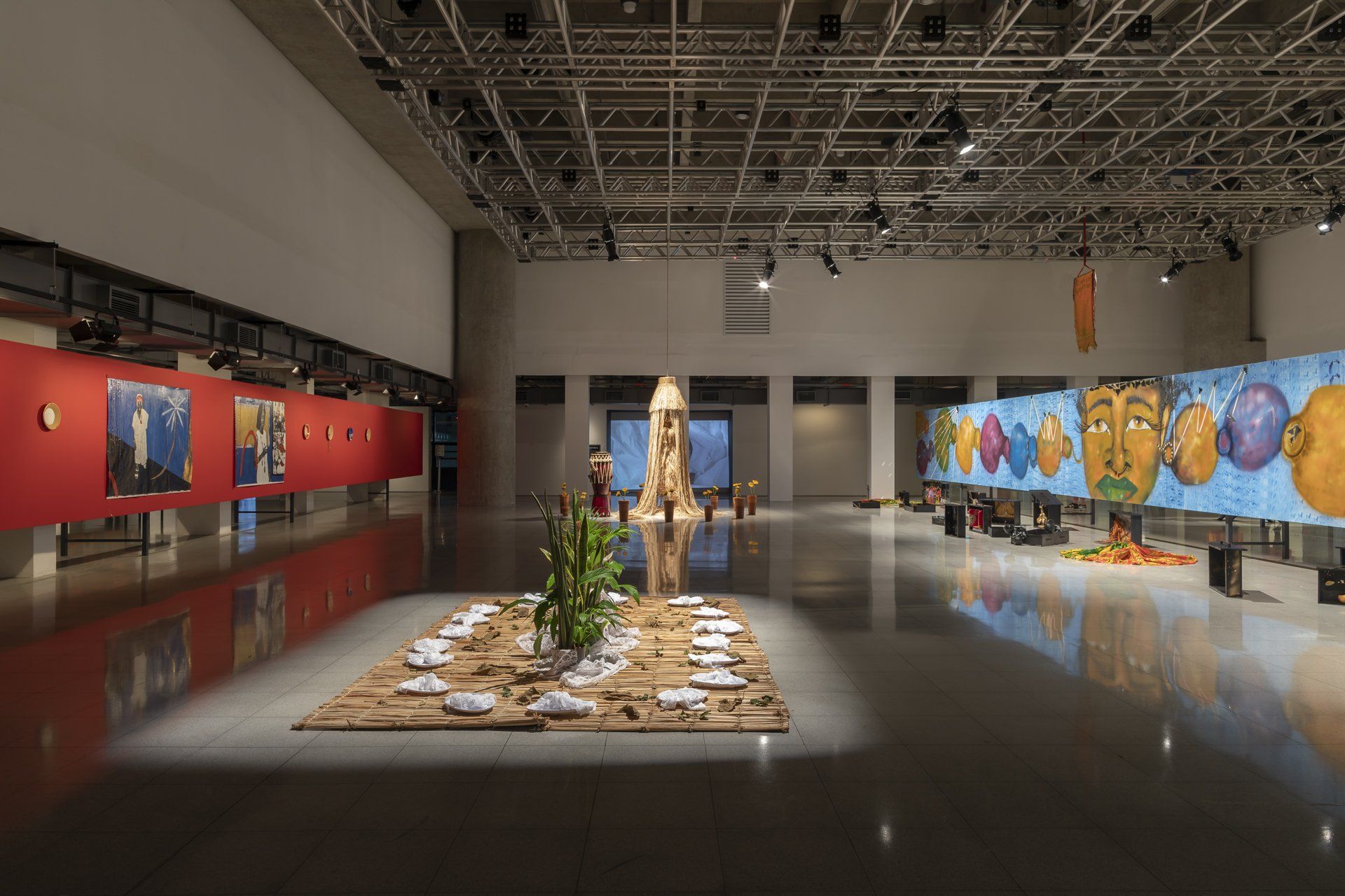 Uma sala ampla com mesa e pinturas na parede.