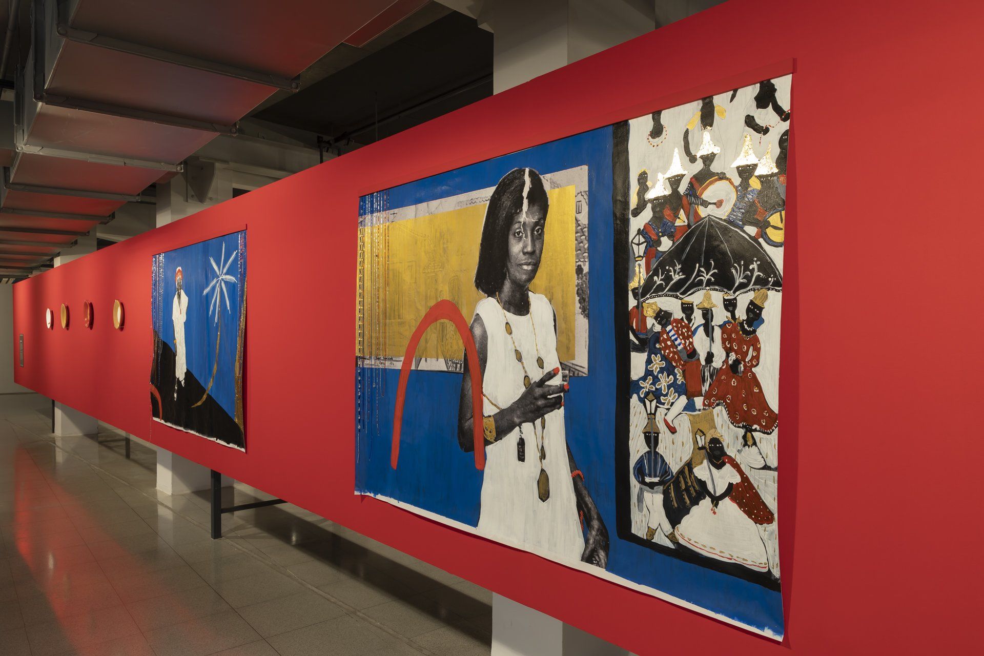 Uma fileira de pinturas em uma parede vermelha de um museu