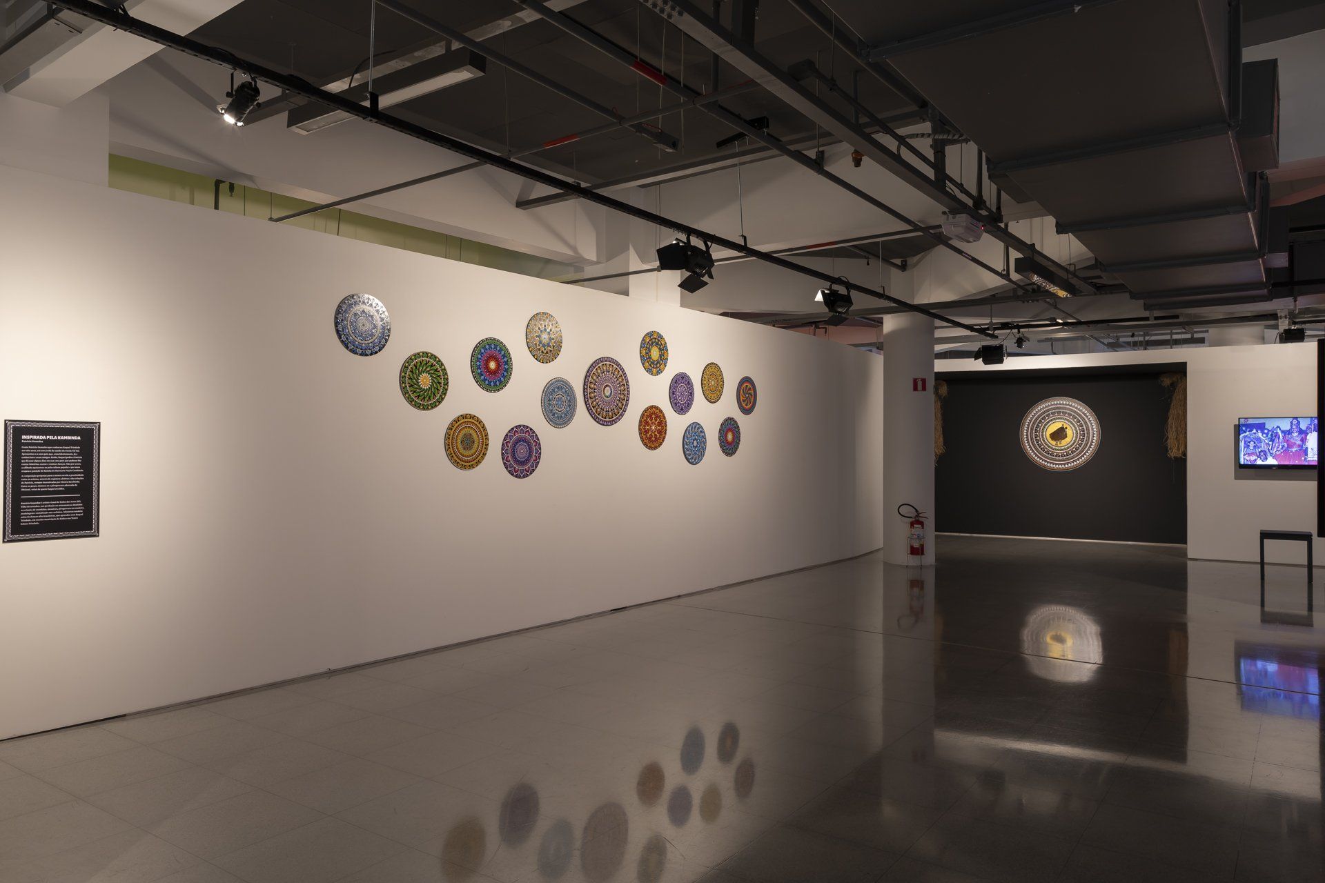 Uma grande sala vazia com muitas pinturas na parede.