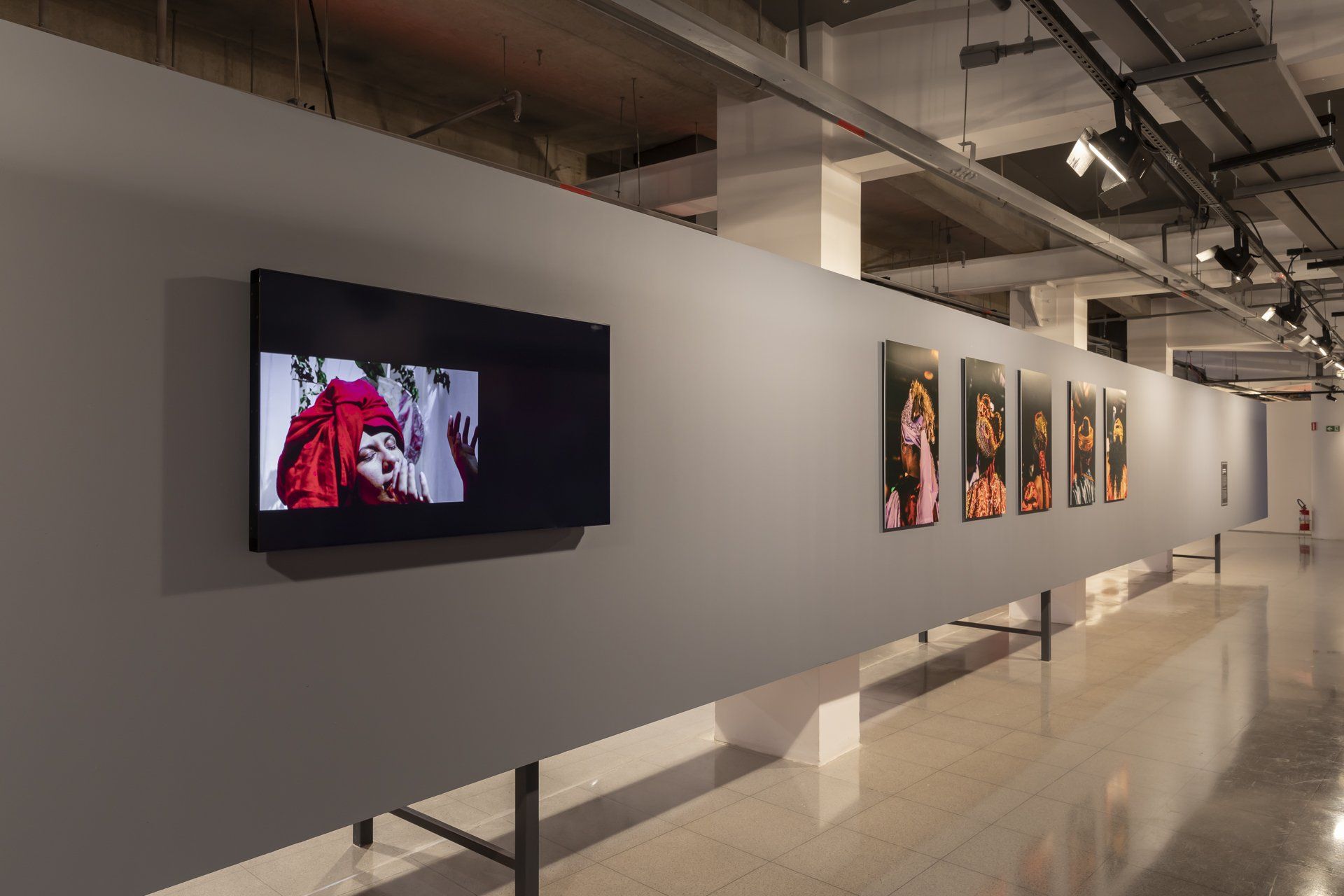 Um longo corredor com uma fileira de quadros na parede.